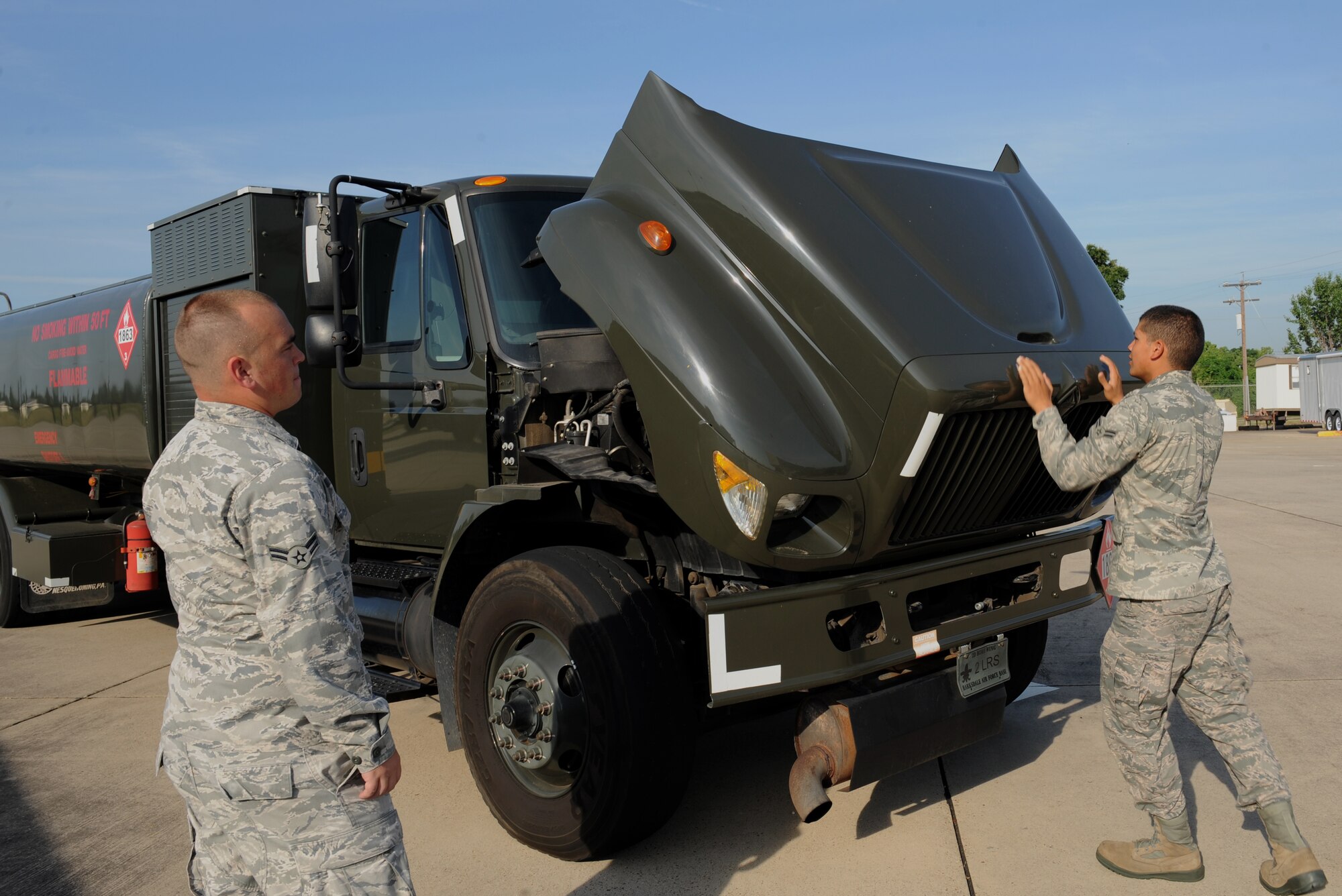 Airman 1st Class Carlos Hernandez, right, 2nd Logistics Readiness Squadron fuels distribution, opens the hood to an R-11 fuel truck on Barksdale Air Force Base, La., July 18, 2013. Fuel trucks are maintained daily to ensure mission readiness and safety. (U.S. Air Force photo/Airman 1st Class Benjamin Gonsier)
