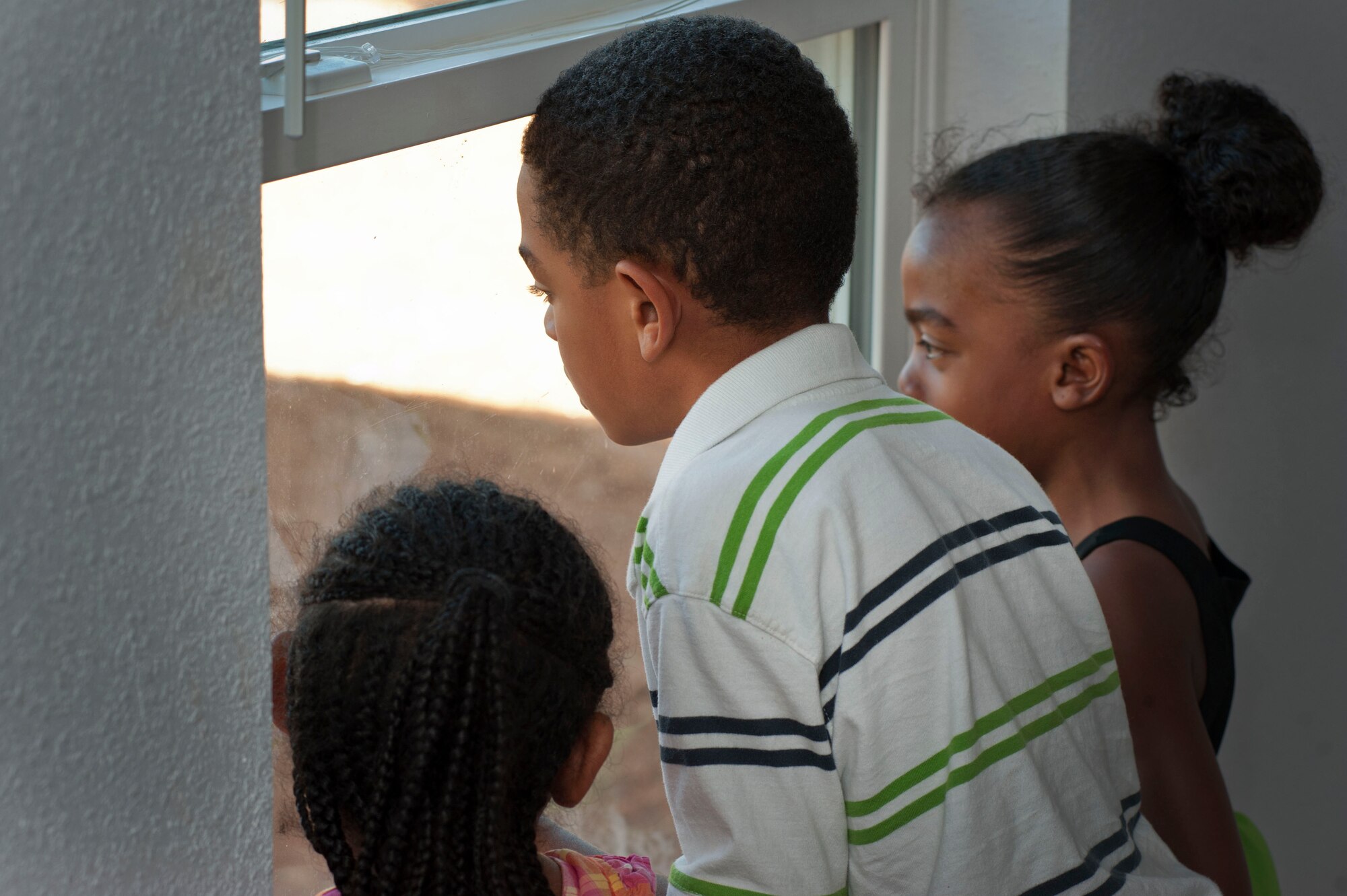Tava Williams’ family stares out the window of their newly constructed house July 13. “All of those long hot days made it worth it,” Williams remarked. (U.S. Air Force photo by Airman 1st Class Jelani Gibson)  