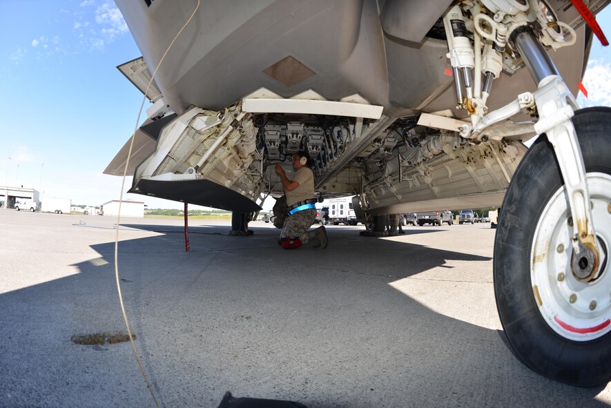 Senior Airman Briana Harrison, 525th Aircraft Maintenance Unit, is preparing to receive the AIM-120 during the quarterly load crew competition here July 12. Teams from the active duty 525th and 90th AMUs and the Reserve 477th AMXS participated in the load crew competition. Harrison along with Staff Sgt. Joe McRae and Senior Airman Jonathan Riggins made up the 525th AMU load crew team that placed first in the event. (U.S. Air Force/Senior Airman Alexander Pritchard) 