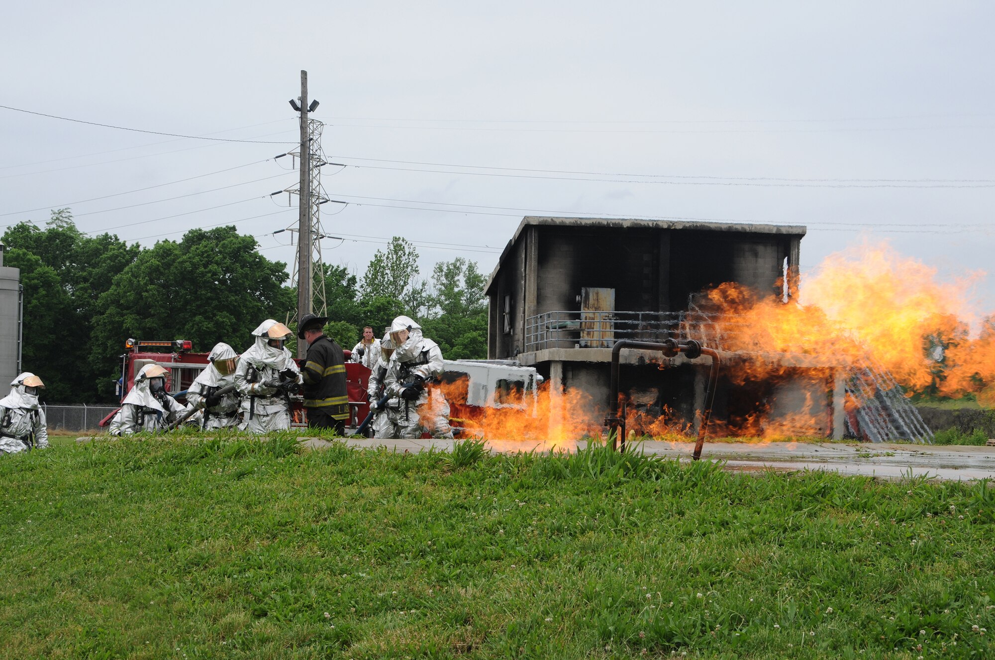 WRIGHT-PATTERSON AIR FORCE BASE, Ohio - Capt. Larry Ables, Dayton Fire Department, instructs firefighters from the 445th Civil Engineer Squadron Fire and Emergency Services Flight on technique as they douse a natural gas leak fire during a training session June 1 at the Dayton Fire Department Training Center. (U.S. Air Force photo/Tech. Sgt. Anthony Springer)