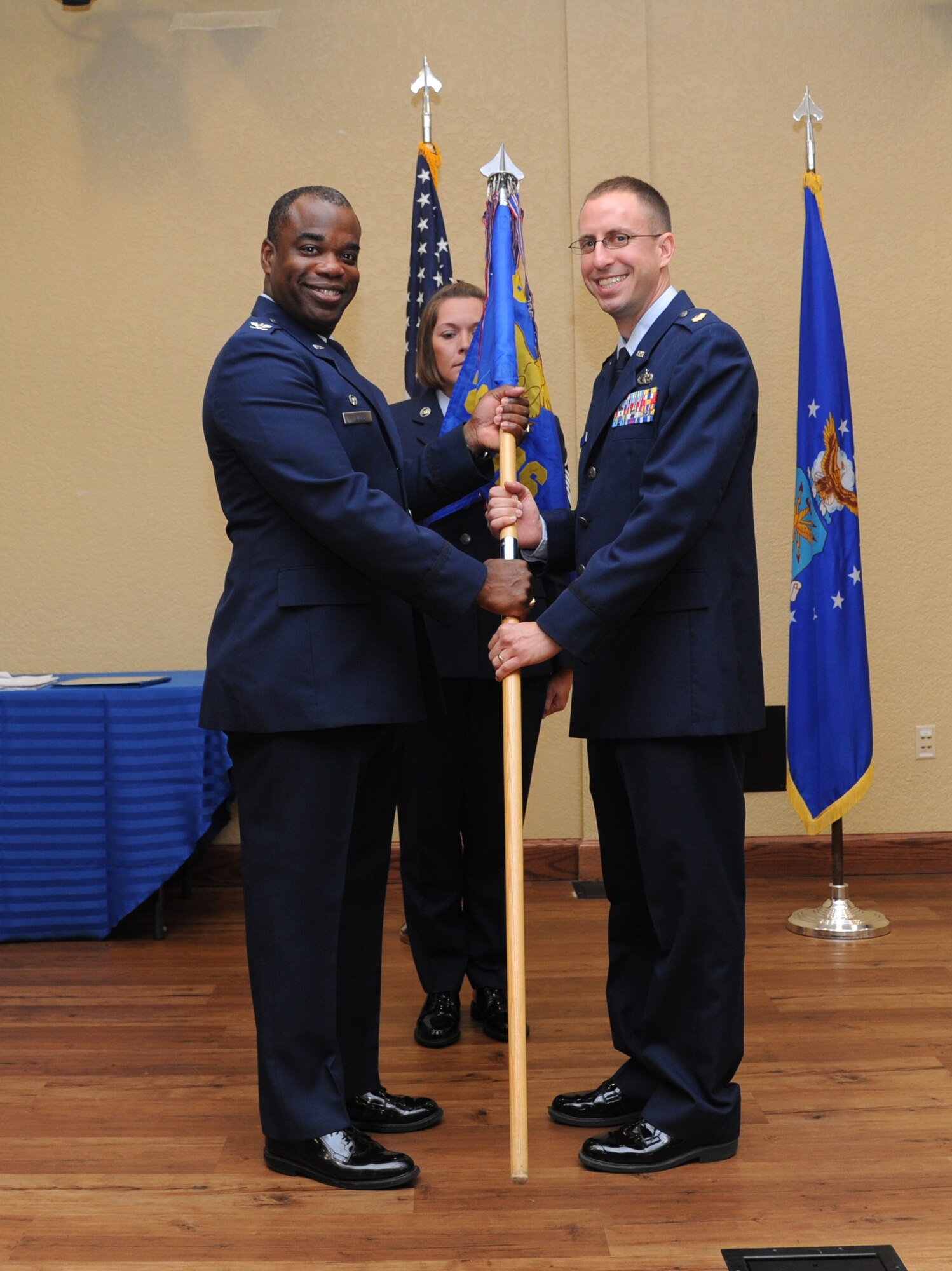 Col. Mark Vivians, 81st Mission Support Group commander, passes the guidon to Maj. Cliff Bayne as he assumes command of the 81st Logistics Readiness Squadron during a change of command ceremony July 18, 2013, at the Bay Breeze Event Center, Keesler Air Force Base, Miss.  Lt. Col. Stephen Wier was the outgoing 81st LRS commander.  (U.S. Air Force photo by Kemberly Groue)