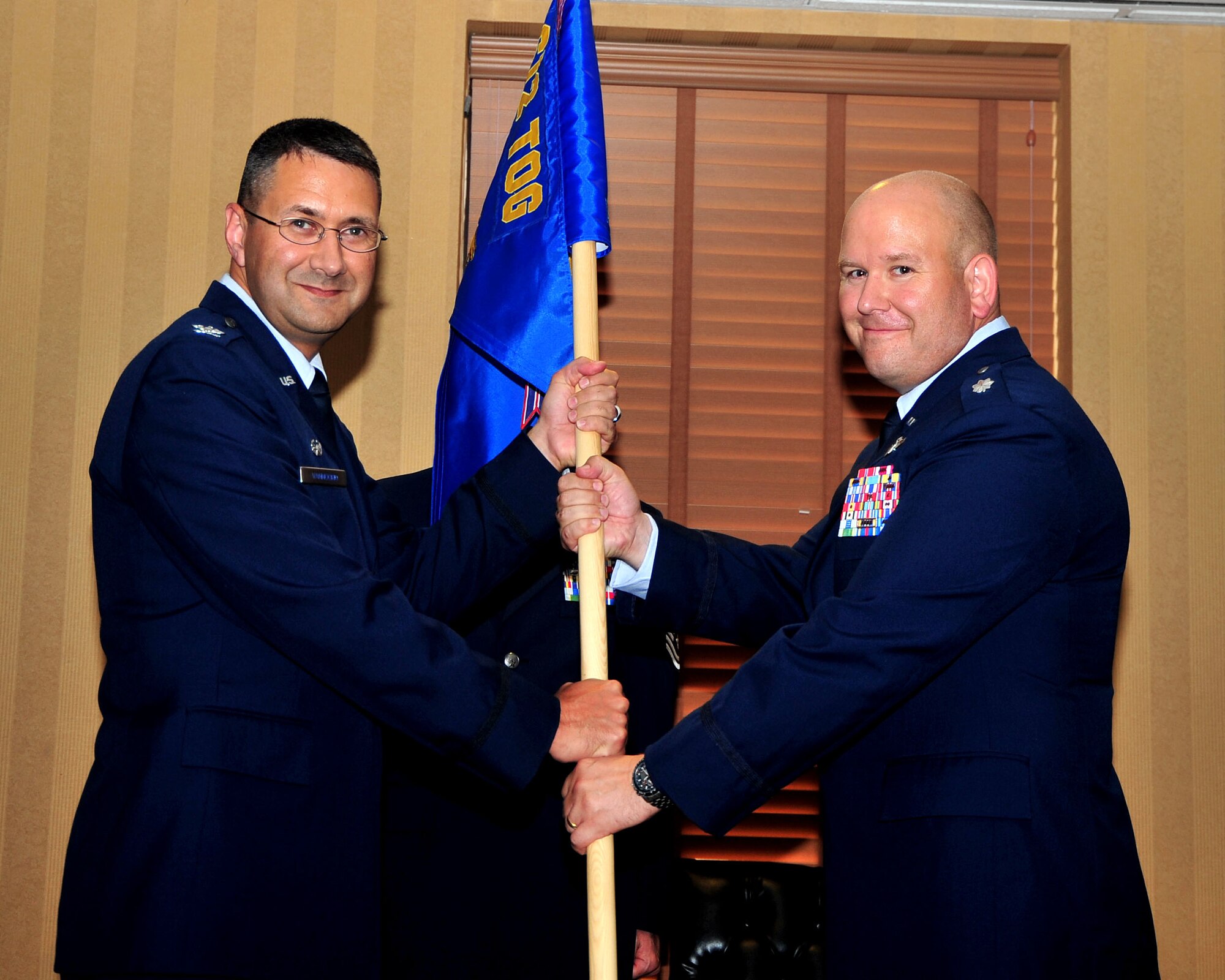 Col. Jonathan VanNoord, 612th Theater Operations Group commander, passes the 612th Support Squadron guidon to Lt. Col. Jeremy Thiel, incoming 612th Support Squadron commander, during a change-of-command ceremony on Davis-Monthan AFB, Ariz., July 16. (USAF photo by 355th Fighter Wing Public Affairs/Released)