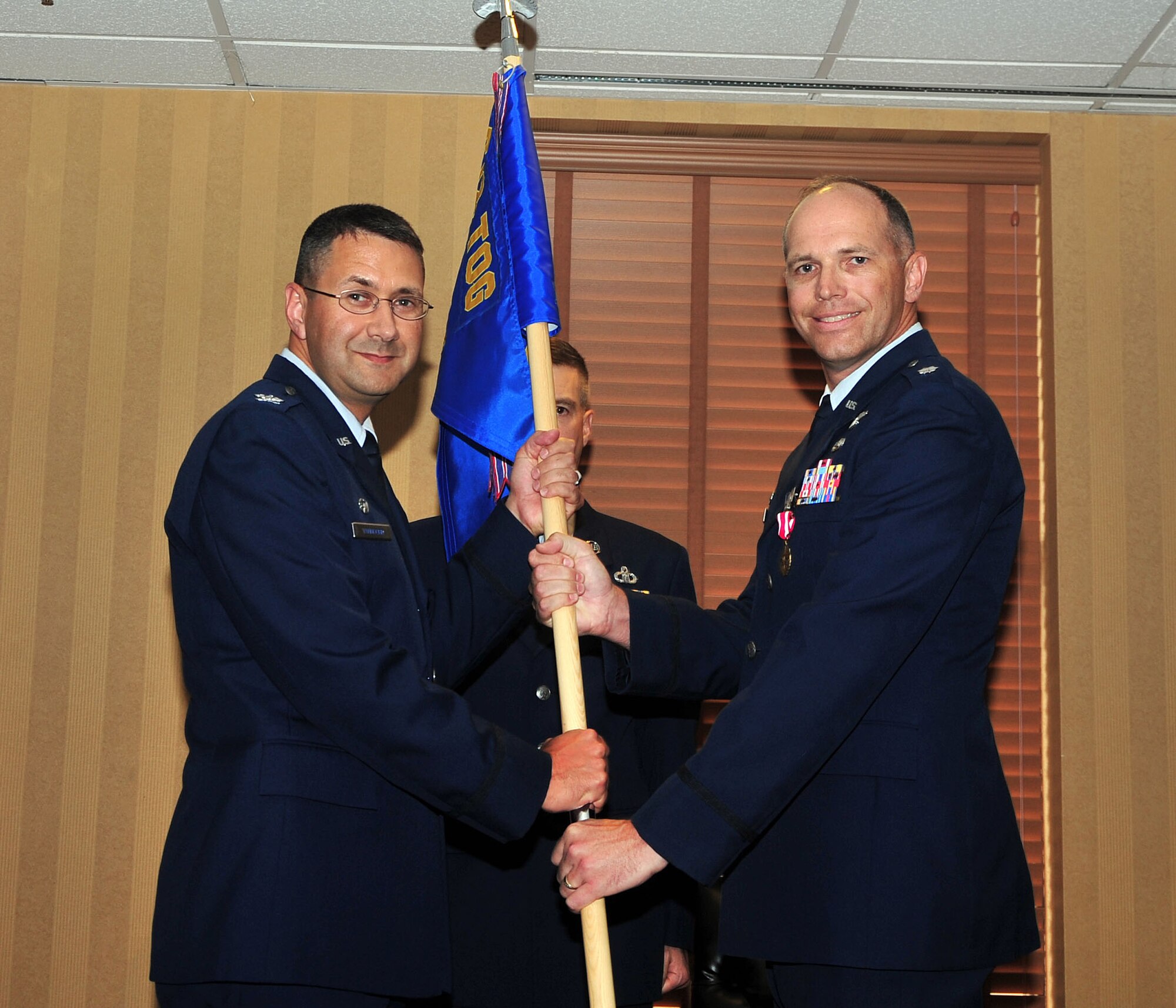 Col. Jonathan VanNoord, 612th Theater Operations Group commander, takes the 612th Support Squadron guidon from Lt. Col. Ryan Hollman, out-going 612th Support Squadron commander, during a change-of-command ceremony on Davis-Monthan AFB, Ariz., July 16. (USAF photo by 355th Fighter Wing Public Affairs/Released)