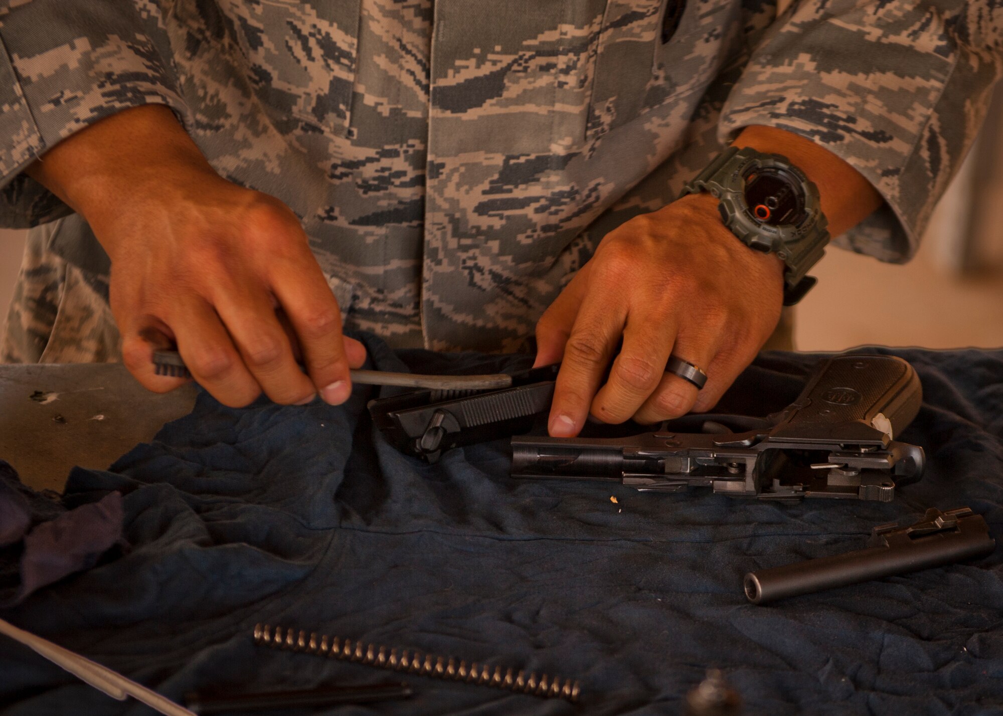 Staff Sgt. Ryan Sablan, 49th Security Forces Squadron patrolman, cleans his disassembled M9 pistol after completing a Combat Arms and Maintenance qualification test at Holloman Air Force Base, N.M., July 10. The training Airmen receive at Holloman’s CATM range ensures they have full knowledge of the weapons used and are able to maintain them properly. (U.S. Air Force photo by A1C Aaron Montoya/Released)
