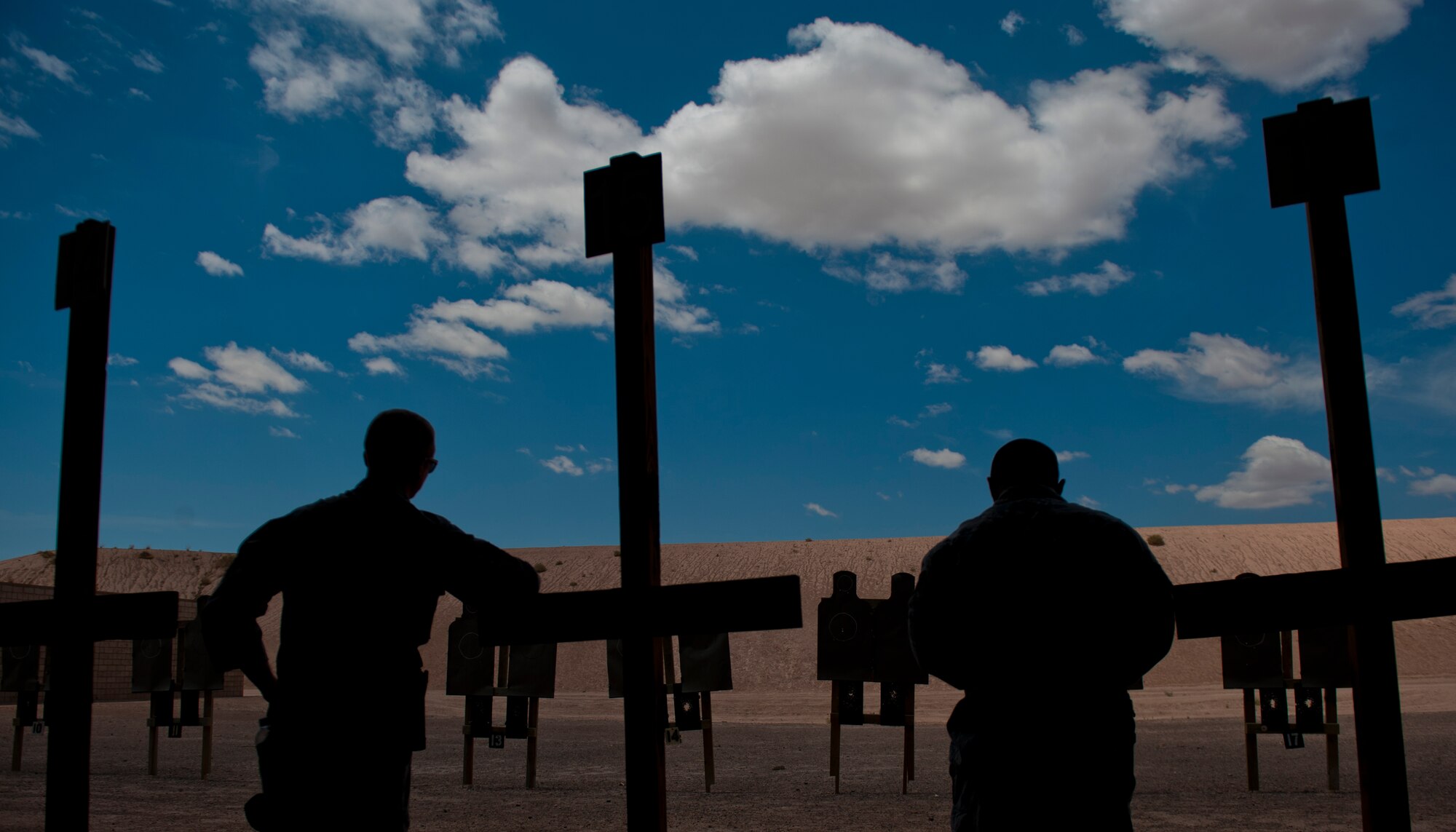 Staff Sgt. Ryan Sablan and Senior Airman Richard Van Blarcum, 49th Security Forces Squadron patrolmen, await the cease fire command to be given so they can check their targets during a Combat Arms and Maintenance qualification test at Holloman Air Force Base, N.M., July 10. The training Airmen receive at Holloman’s CATM range ensures they are capable and confident when handling their weapon. (U.S. Air Force photo by A1C Aaron Montoya/Released)