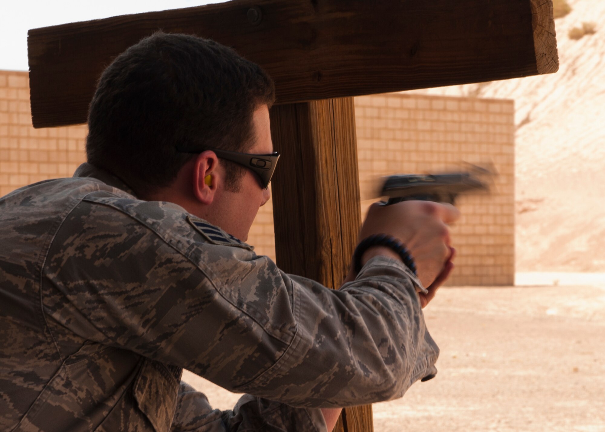 Senior Airman Richard Van Blarcum, 49th Security Forces Squadron patrolman, fires his M9 pistol from the crouched position during a Combat Arms and Maintenance qualification test at Holloman Air Force Base, N.M., July 10. The training Airmen receive at Holloman’s CATM range ensures they are capable and confident when handling their weapon. (U.S. Air Force photo by A1C Aaron Montoya/Released)