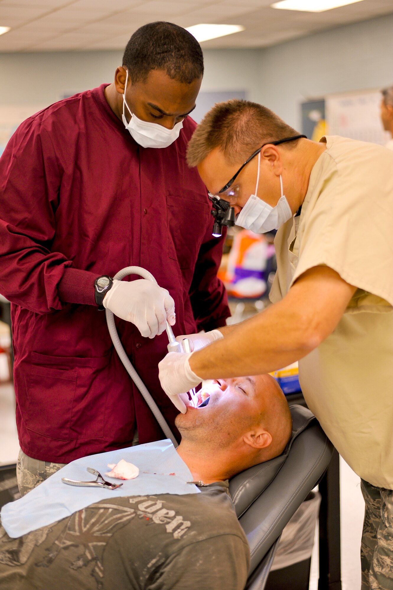 Lt. Col. Shawn Thompson, a dentist with the 180th Fighter Wing, Ohio Air National Guard, and Senior Airman Bruce Moman, a medical technician also with the 180th FW, extract a tooth July 15, 2013, at Martin Middle School in Martin, Tenn. Thompson and about 130 service members from the Air National Guard, Naval Reserves and the Army came together in the West Tenn. Community to provide free medical care as part of Innovative Readiness Training in support of the two-week “Hope of Martin” health fair. As of July 15, the medical team had extracted over 1,100 teeth. Air National Guard photo by Master Sgt. Beth Holliker (Released).   Air National Guard photo by Master Sgt. Beth Holliker (Released). 