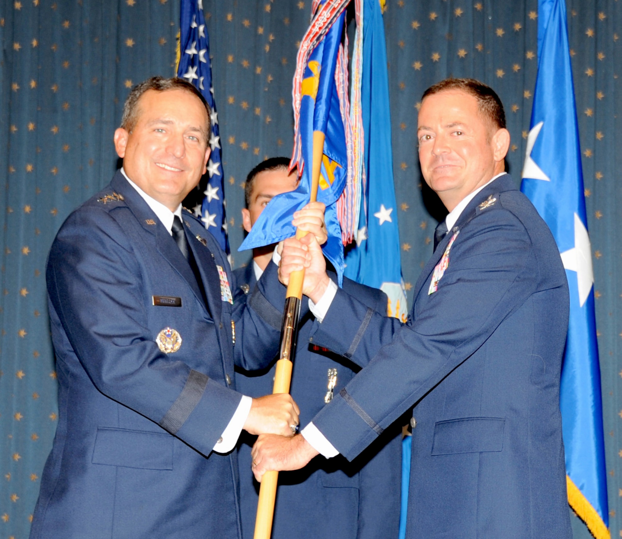 Lt. Gen. Stephen Mueller, Inspector General of the Air Force, passes the guidon to Col. Richard Coe, new Air Force Inspection Agency  commander at a change of command ceremony July 12. Most recently, Coe served as chief of staff at Pacific Air Forces Command, headquartered at Hickam Air Force Base, Hawaii. (Photo by Dennis Carlson)