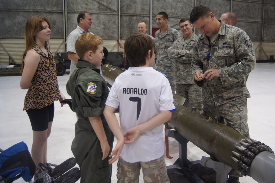 U.S. Air Force Tech. Sgt. Dustin Krupa, 333rd Aircraft Maintenance Unit weapons lead crew representative, presents a coin to the members of the Holich family during their “pilot for a day” trip at Seymour Johnson Air Force Base, N.C., June 21, 2013. The family was able to see different aspects of the 4th Fighter Wing mission in action to fulfill the dream of Christopher Holich, a 9 year old living with mitochondrial disease which has caused kidney failure. (Courtesy photo)