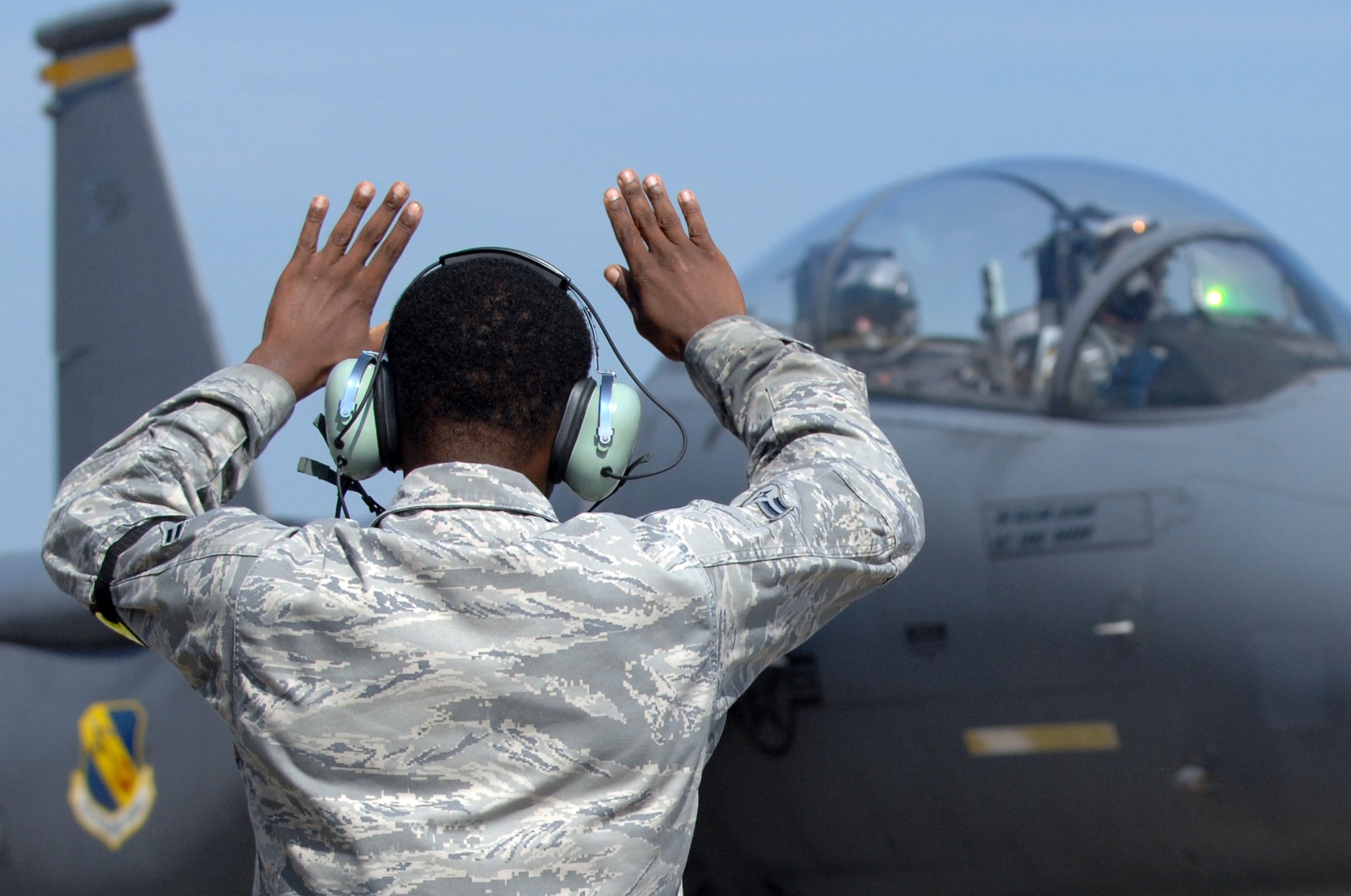U.S Air Force Airman 1st Class Alain Joseph, 4th Aircraft Maintenance Squadron crew chief, clears an F-15E Strike Eagle assigned to the 336th Fighter Squadron to begin taxiing to the runway at Seymour Johnson Air Force Base, N.C., July 17, 2013.  The resumption of flying for units in the Combat Air Force represents the Air Force’s commitment to current combat readiness.  (U.S. Air Force photo by Airman 1st Class Brittain Crolley/Released)