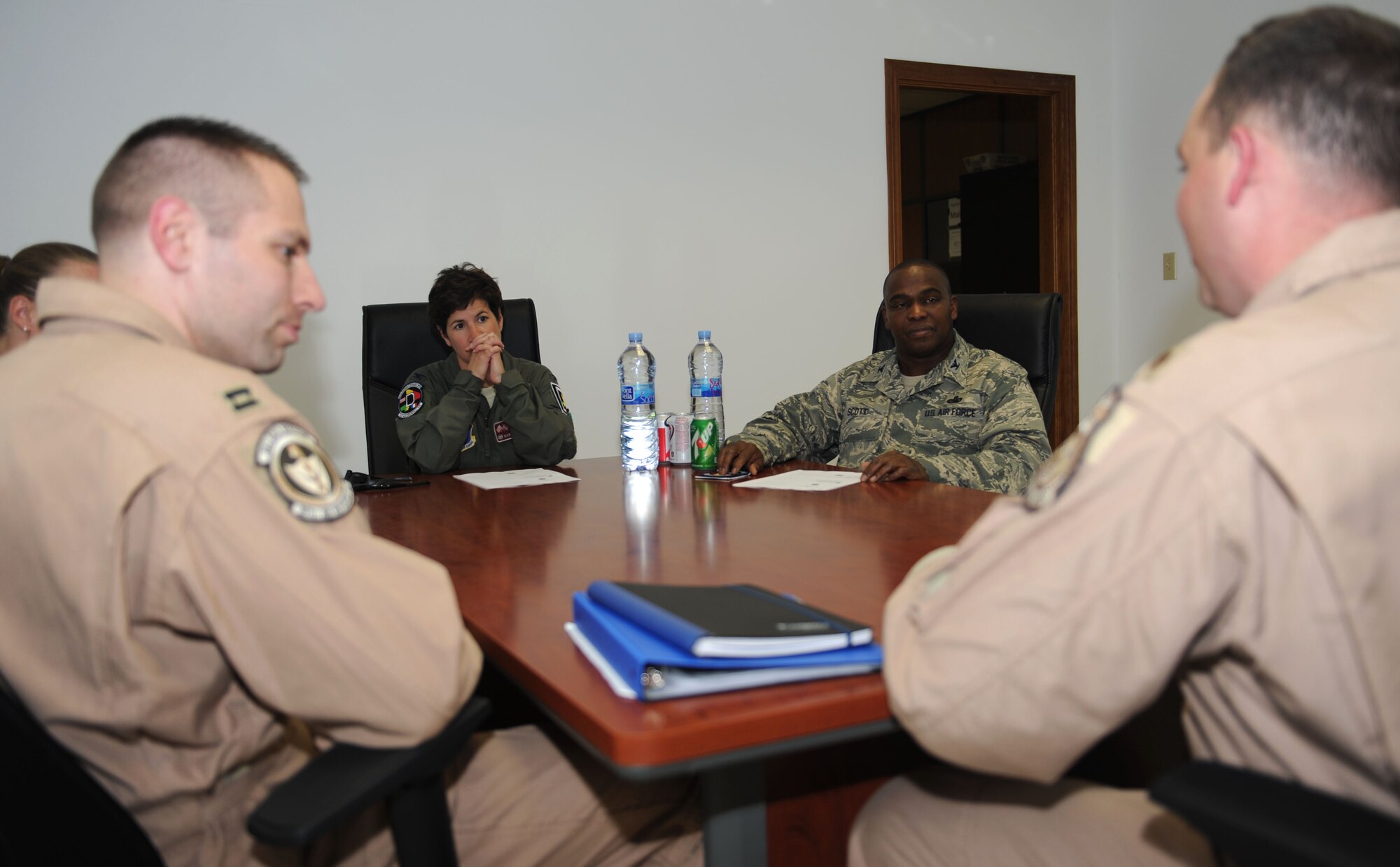 Foreground from left, Capt. Brandon Gillet, 351st Expeditionary Air Refueling Squadron director of operations, and Maj. Ryan Ferdinandsen, 351st EARS commander, deliver a briefing to Col. Nancy Bozzer, 100th Operations Group commander, and Col. Earl Scott, 100th Maintenance Group commander, July 16, 2013, at Moron Air Base, Spain. Bozzer and Scott reviewed mission progress and addressed needs of the base. (U.S. Air Force photo by Airman 1st Class Preston Webb/Released)