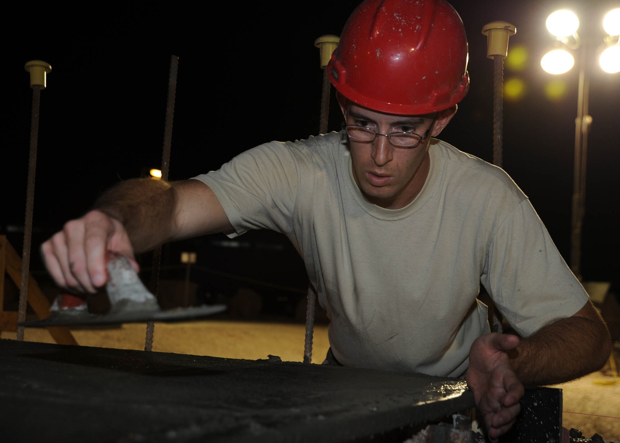 Tech. Sgt. Thomas Bryant uses a float to compact leveled cement at the 379th Air Expeditionary Wing in Southwest Asia, July 9, 2013. The 557th Expeditionary RED HORSE Squadron is building a Contingency Aeromedical Staging Facility that will house and provide medical care to wounded service members prior to medical evacuation. Bryant is the 557th ERHS CASF project manager deployed from Malstrom Air Force Base, Mont. (U.S. Air Force photo/Senior Airman Bahja J. Jones) 