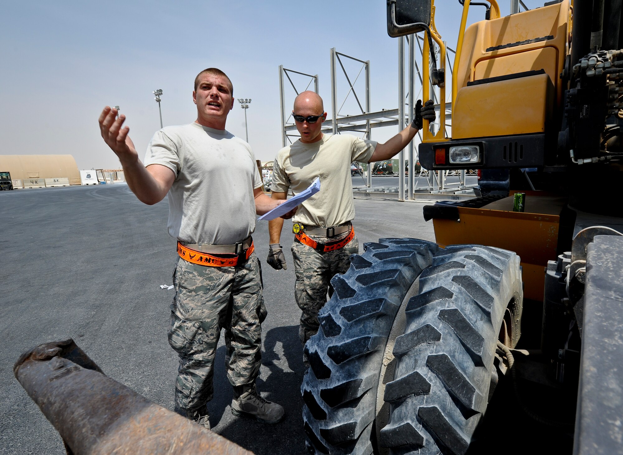 Senior Airman Jeffrey Montgomery and Staff Sgt. Adam Rozehnal check to make sure an excavator has the proper documentation and hazardous materials are stored correctly before it is loaded onto a C-17 Globemaster III at the 379th Air Expeditionary Wing in Southwest Asia, July 17, 2013. Montgomery is an 8th Expeditionary Air Mobility Squadron air transportation technician deployed from Joint Base Charleston, S.C., and Rozehnal is an 8th EAMS air transportation supervisor deployed from Joint Base McGuire-Dix-Lakehurst, N.J. (U.S. Air Force photo/Senior Airman Benjamin Stratton)