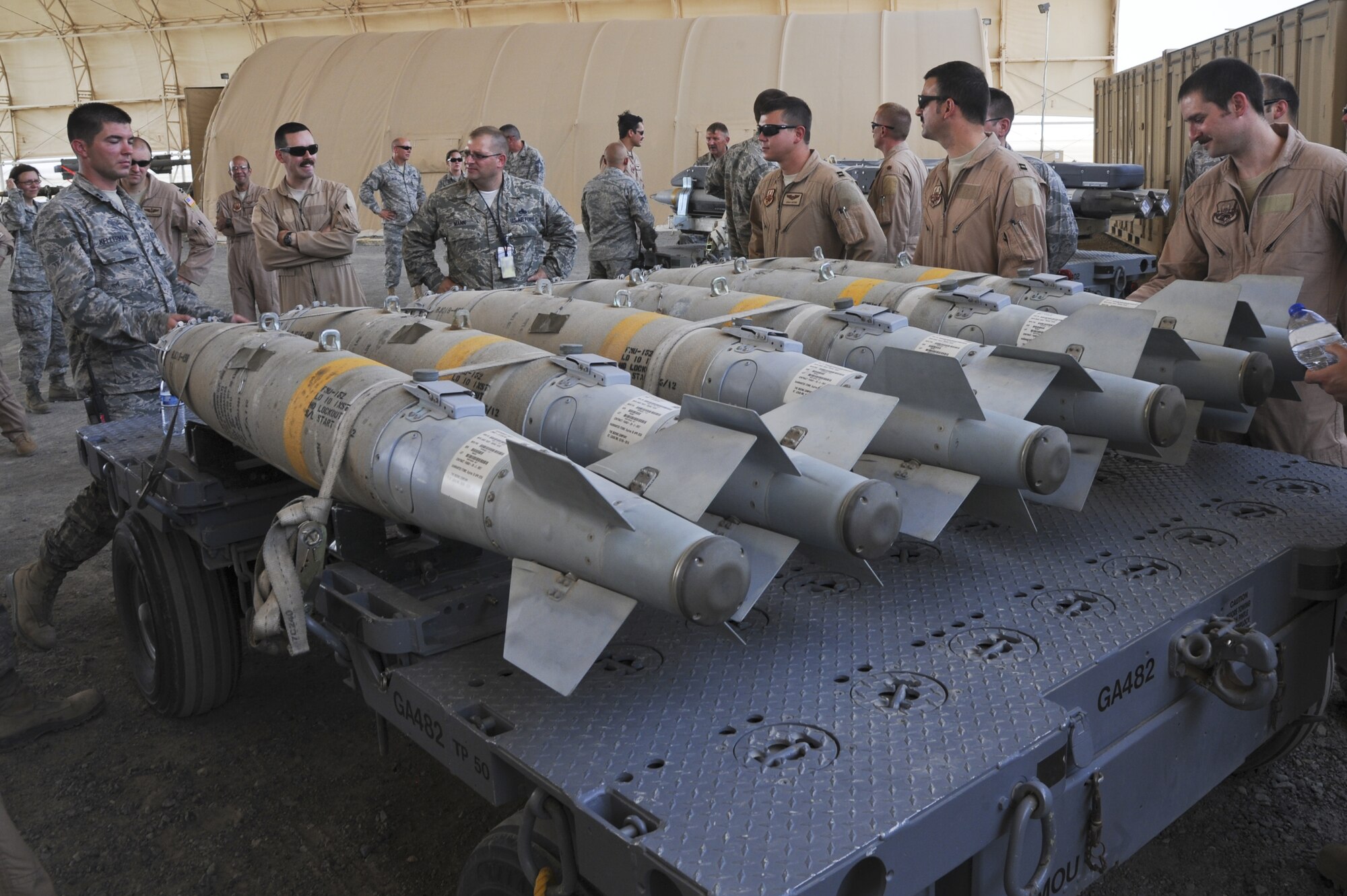 U.S. Air Force Capt. Patrick Kellerman, left, 380th Expeditionary Maintenace Squadron munitions flight chief, explains the low collateral capabilities of the GBU-38 version four to pilots of the 380th Air Expeditionary Wing at the temporary munitions storage area in an undisclosed location in Southwest Asia July 15, 2013. The bomb has only 27 pounds of explosive material and is used for precision targets where a small blast is needed. The pilots took a tour of the temporary munitions storage area in the hopes of gaining more knowledge of what goes into building munitions. Kellerman calls Fayetville, Ga., home and is deployed from Joint Base Elmendorf-Richardson, Alaska. (U.S. Air Force photo by Senior Airman Jacob Morgan)