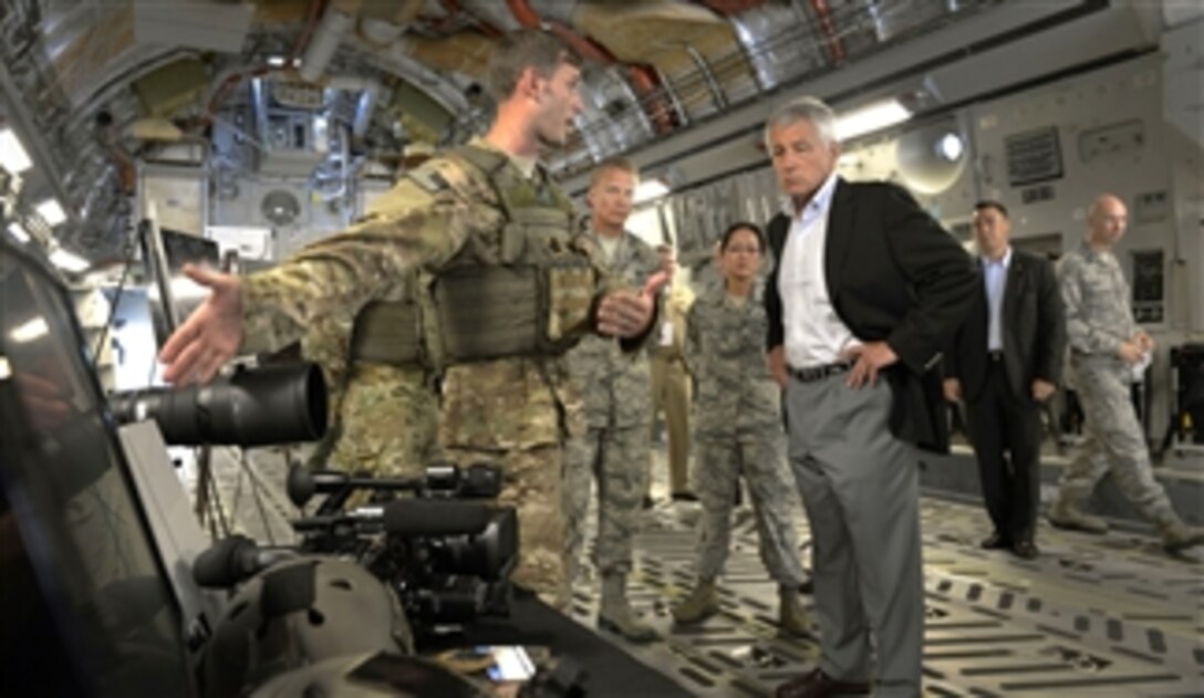 Secretary of Defense Chuck Hagel, right, listens to an airman from the 1st Combat Camera Squadron as he tours an Air Force C-17 Globemaster III aircraft at Joint Base Charleston in Charleston, S.C., on July 17, 2013.  Hagel is visiting the base to conduct town hall meetings and receive briefings from Air Force and civilian leaders on the impact of furloughs and sequestration on their lives and operations.  