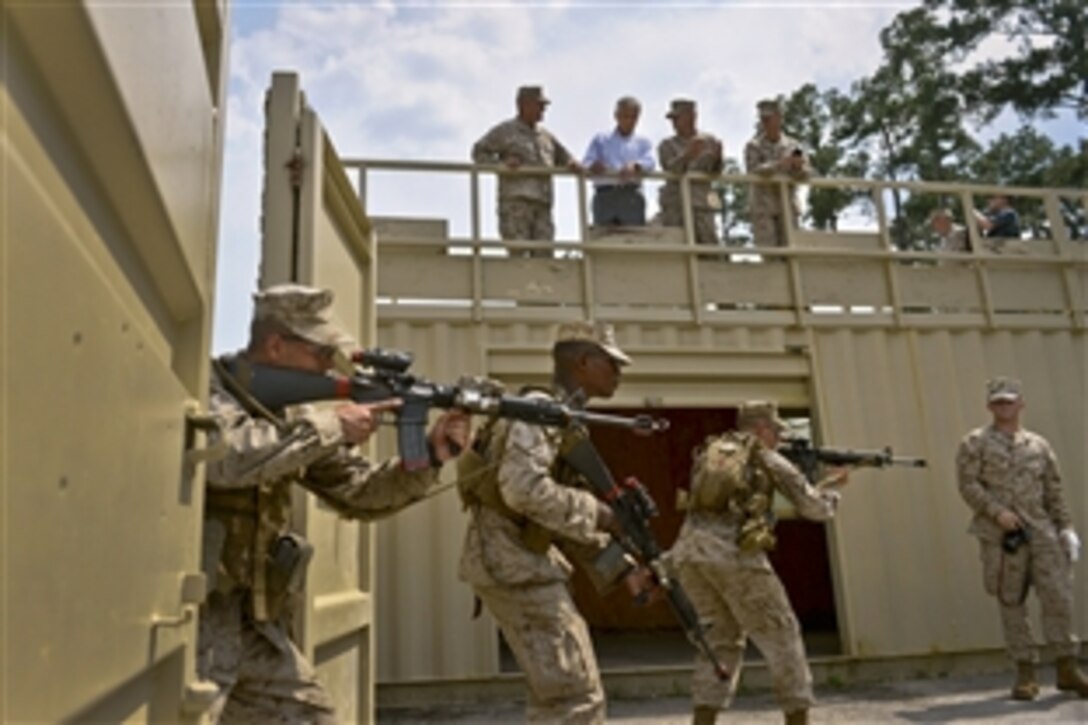 Defense Secretary Chuck Hagel looks on from above as Marines train for urban warfare at the School of Infantry East near Jacksonville, N.C., July 17, 2013, as he wraps up a three-day trip to several East Coast bases.