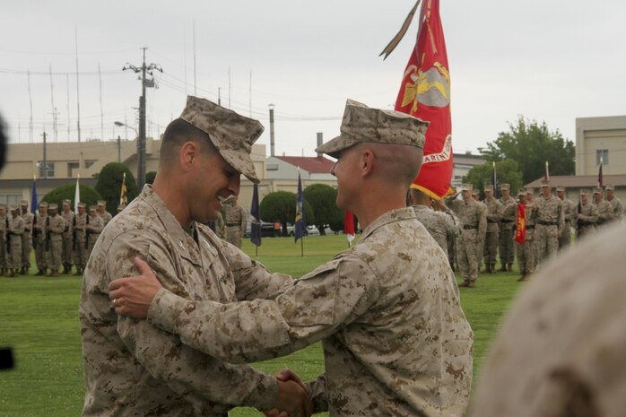 Col. James C. Stewart, right, former station commanding officer, shakes hands with Col. Robert V. Boucher during the change of command and retirement ceremony held at the parade deck at Marine Corps Air Station Iwakuni, Japan, July 12, 2013. Stewart finished his career with 29 years of service. Boucher comes to Iwakuni from his previous assignment at the Pentagon in Washington, D.C.