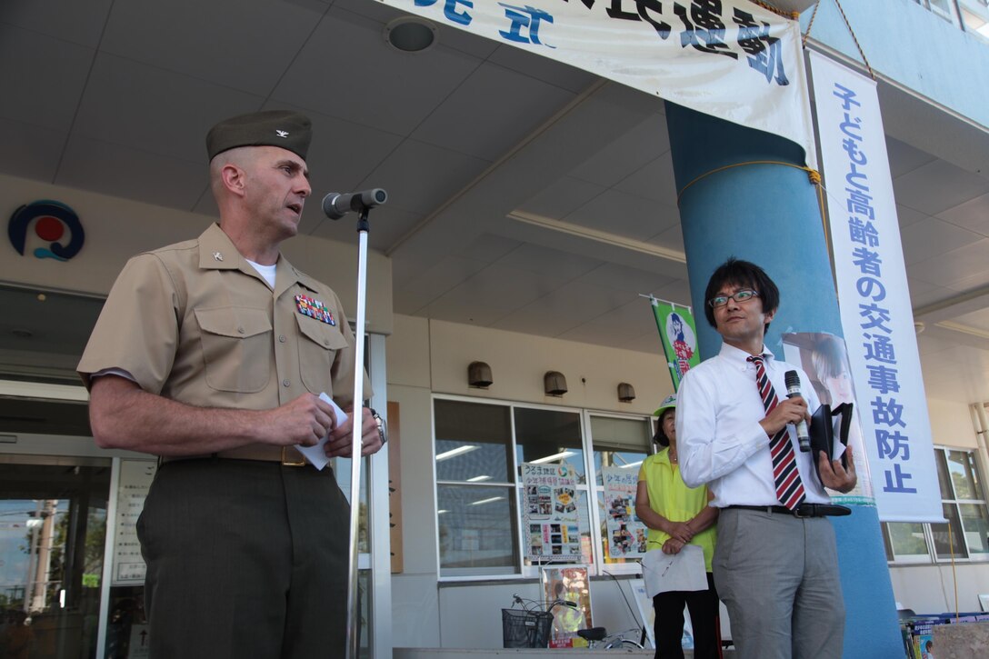 Col. Michael W. Taylor, left, speaks to community members during the opening ceremony of the 2013 Okinawa Drive Safety Campaign July 9 at the Uruma City Police Station. “This drive safe campaign is important because any time someone gets behind the wheel while distracted or impaired, they are running the risk of seriously injuring themselves or others,” said Taylor. Senior leaders from Camps Courtney and McTureous attended the opening ceremony to represent U.S. service members’ commitment to safe driving. Taylor is the camp commander of Camps Courtney and McTureous. (U.S. Marine Corps photo by Lance Cpl. Brandon C. Suhr/Released)