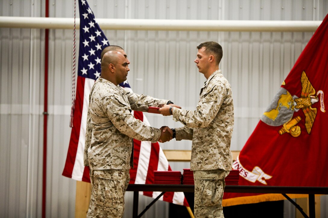 Cpl. Alexander Micciche, a combat engineer with Black Sea Rotational Force 13 and Denver, Colo., native and the "gung-ho" award recipient for the most motivated Marine in Corporals Course class 44-13, receives his  graduation certificate, June 23, 2013 in Mihail Kogalniceanu Military Base, Romania. Marines with BSRF-13 who attended Corporals Course learned the basics of being a non-commissioned officer in the United States Marine Corps. Corporals Course is a formal school that is a requirement for all corporals that want to be eligible for the rank of sergeant.