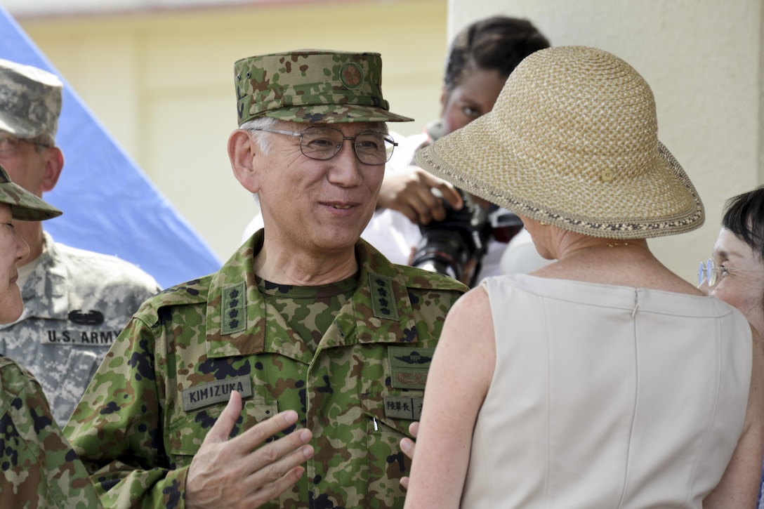 Gen. Eiji Kimizuka speaks with Bonnie Amos July 19 at the Camp Foster parade deck following the III Marine Expeditionary Force change of command ceremony. Lt. Gen. John E. Wissler assumed command of III MEF from Lt. Gen. Kenneth J. Glueck Jr. “To the JSDF … and the (Republic of Korea) Marine Corps, we truly look forward to our continued service together and the security of the region,” said Wissler. “And to our Okinawa partners, Sue (Wissler) and I tremendously look forward to making lasting friendships and continuing to build on this great opportunity for the United States.” Kimizuka, the chief of staff of the Japan Ground Self-Defense Force, attended the ceremony with other key leaders of the JSDF and ROK Marine Corps. Bonnie Amos is the wife of Gen. James F. Amos, the commandant of the Marine Corps. (U.S. Marine Corps photo by Cpl. Mark W. Stroud/Released)