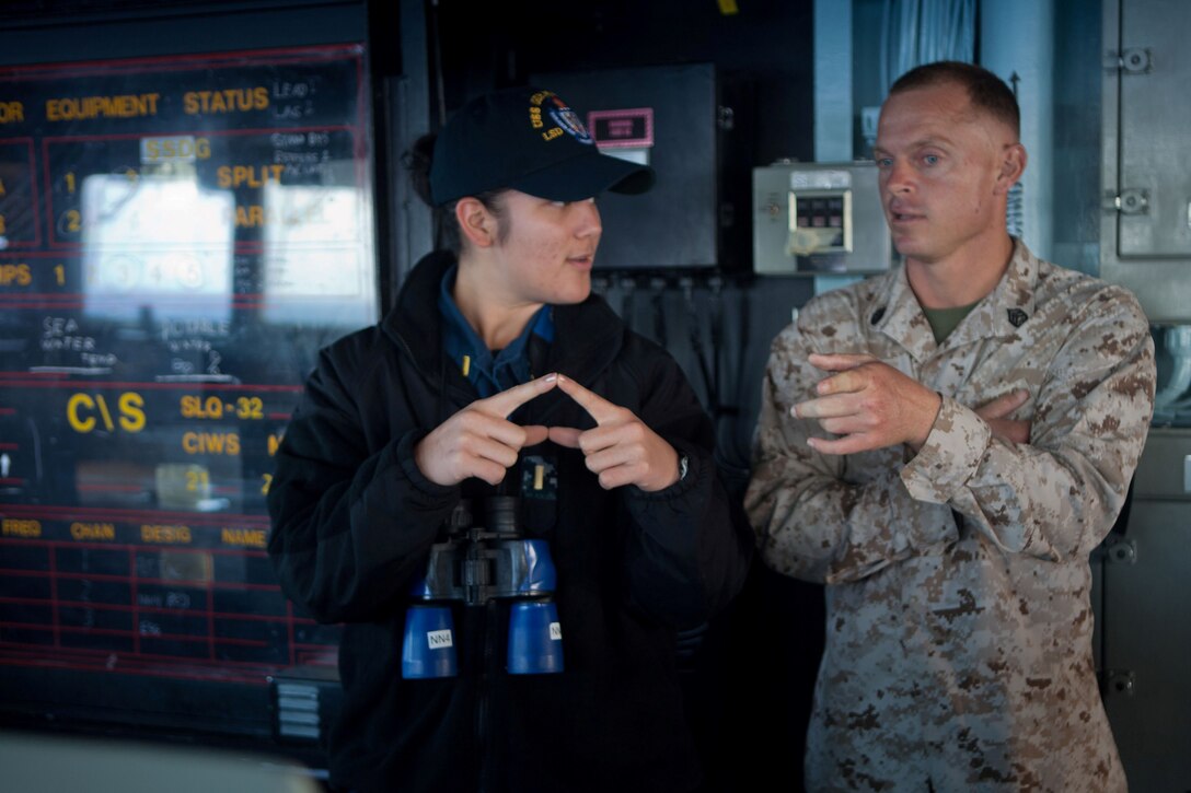 Staff Sgt. Michael W. Burkhart, an amphibious assault vehicle section leader with Company G., Battalion Landing Team 2nd Battalion, 4th Marines, 31st Marine Expeditionary Unit, and native of Norman, Okla., answers a ship piloting question given by Ensign Andrea M. Stoke, communications officer with the operations department, USS Germantown, and native of Chula Vista, Calif., here, July 15. Burkhart is training to be a qualified helmsman of small-deck Navy vessels in addition to  performing his duties as an AAV staff noncommissioned officer in support of a bilateral exercise in Australia. The 31st MEU is embarked aboard the Bonhomme Richard Amphibious Ready Group, currently participating in Talisman Saber 2013,a biennial training exercise with the Australian military designed to enhance multilateral collaboration in support of future combined operations, natural disaster, humanitarian and emergency response.