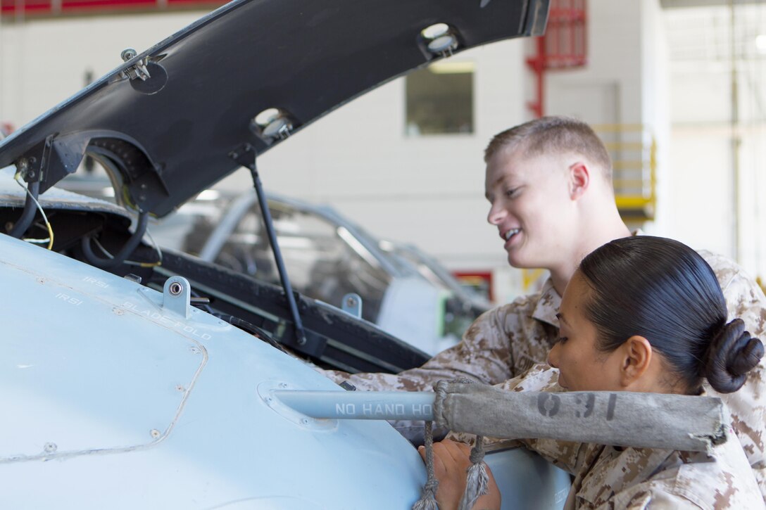 Lance Cpl. Everlin Juarez-Hernandez, right, avionics technician, 3rd Marine Aircraft Wing’s third Marine of the Quarter for 2013 and a Long Beach, Calif. native, and Cpl. Kyle Christensen, left, 1st Marine Expeditionary Force’s fourth Marine of the Quarter for 2012 and a Eureka, Calif. native, replace a battery in the nose compartment in a UH-1Y Huey aboard Marine Corps Air Station Camp Pendleton, Calif., July 15. Sgt. Michael Burgess, noncommissioned officer-in-charge of fire control at Marine Light Attack Helicopter Training Squadron 303 and a Ramona, Calif. native, led these Marines to victory at the quarterly awards and is recognized as part of the committed and engaged leadership campaign. 