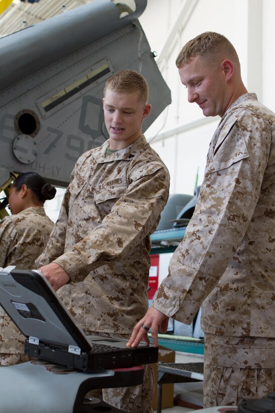 Sgt. Michael Burgess, right, noncommissioned officer-in-charge of fire control at Marine Light Attack Helicopter Training Squadron 303 and a Ramona, Calif. native, refers to an aircraft maintenance publication aboard Marine Corps Air Station Camp Pendleton, Calif., July 15. Burgess mentors Cpl. Kyle Christensen, left, 1st Marine Expeditionary Force’s fourth Marine of the Quarter for 2012 and a Eureka, Calif. native, one of the seven Marines Burgess has prepped to win the these quarterly awards.