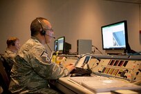 Master Sgt. Jose Torres, a cyber systems manager on the Joint Task Force - Space Transportation System team, works with Maj. Normand Burroughs, team director of communications, to ensure all computer requirements are met prior to and during the shuttle launch mission. 