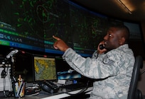 Staff Sgt. Jose Grimes, search and rescue duty officer with the Air Force Rescue Coordination Center at Tyndall Air Force Base, Fla., monitors the radar as he coordinates with another agency during a SAR mission. Sergeant Grimes played a critical role in locating a downed aircraft March 7 near the Canadian border in Maine and coordinating bi-national assets to rescue the aircrew member who survived.
