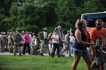 Service members with Combat Logistics Battalion, 2nd Marine Logistics Group walk with family, friends and loved ones to buses, on which they will embark for Afghanistan aboard Camp Lejeune, N.C., July 10, 2013. Marines and sailors bade farewell to family and friends at an event before leaving to perform logistics operations in support of Operation Enduring Freedom.