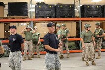 Jump Master Instructor Sgt. 1st Class Walter Veazey (right) instructs Marines with 2nd Marine Logistics Group and other units going through a jump master course aboard Camp Lejeune, N.C., July 19, 2013. The Marines in the course formed a circle where they could inspect one another’s equipment and learn what to look for during missions.  (U.S. Marine Corps photo by Lance Cpl. Shawn Valosin)