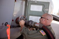 U.S. Air Force Master Sgt. Chuck Watkins, 115th Airlift Squadron, California Air National Guard, connects a fuel hose to a C-130J Hercules while preparing the aircraft for firefighting operations at Dyess Air Force Base, Texas, April 18, 2011.  The C-130 is equipped with the Modular Airborne Firefighting System(MAFFS) which is capable of dispensing 3,000 gallons of water or fire retardant in under 5 seconds.  