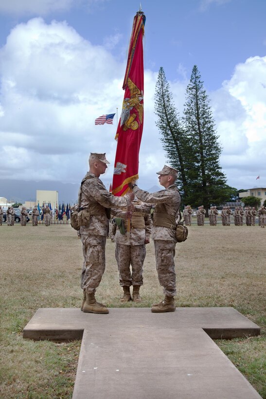 Incoming commanding officer Col. Timothy Winand (left), receives the 3rd Marine Regiment’s colors from outgoing commanding officer Col. Nathan Nastase, symbolizing the exchange of command during 3rd Marine Regiment’s change of command ceremony, July 17, 2013. (U.S. Marine Corps photo by Lance Cpl. Nathan Knapke)