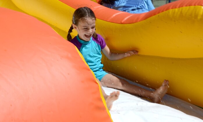 Natalie Hayes, 5, reaches the bottom of the water slide during the Summer Splashdown at Riseley Field, July 13, 2013. (U.S. Marine Corps photo by Kristen Wong)
