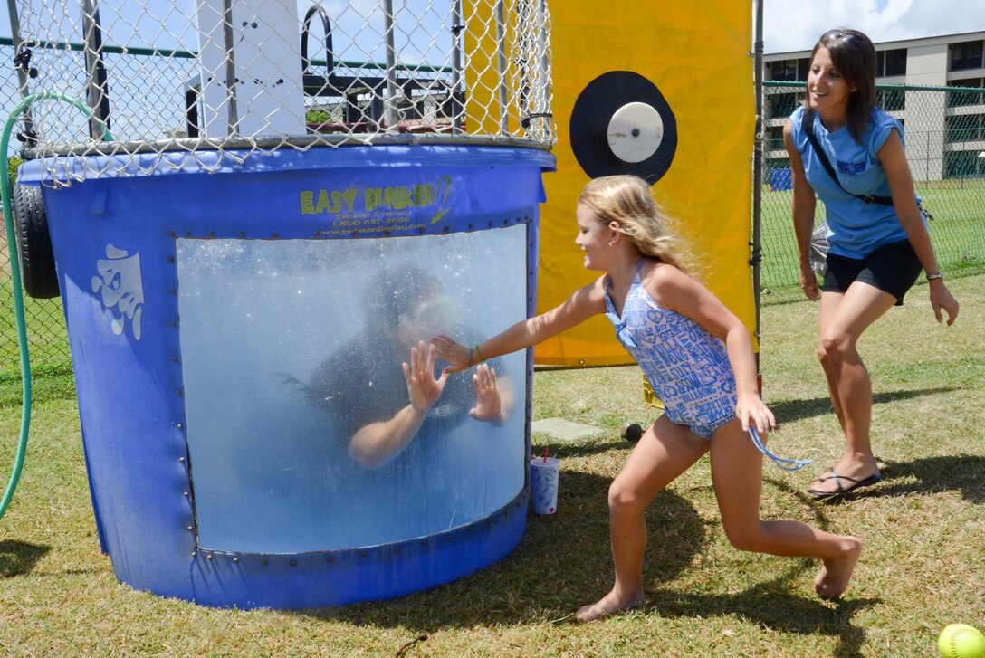 Olive Marsden, 5, gives a high five to Tanisha Milca, a program technician at the Youth Activities Center, through the dunk tank, July 13, 2013. (U.S. Marine Corps photo by Kristen Wong)