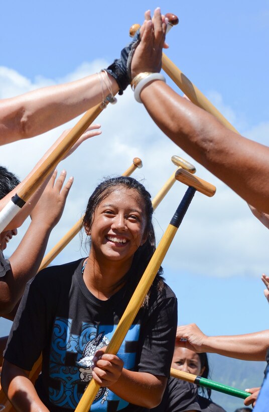 Alanis Pebenito, a member of Keola O Ke Kai Canoe Club, comes ashore after competing in her division during the John D. Kaupiko Regatta, July 14, 2013. Her teammates touched hands to form a victory “tunnel” through which the competitors walk after the race. (U.S. Marine Corps photo by Kristen Wong)