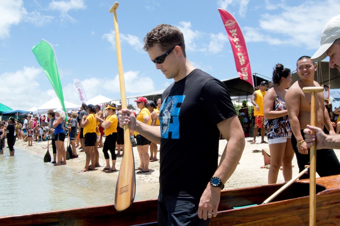 Navy Lt. Ian Rummel, a pilot with Commander, Patrol and Reconnaissance Wing 2 and regatta competitor, prepares to board the canoe for the Men's Senior division at the John D. Kaupiko Regatta, July 14, 2013. The regatta was hosted by Na Koa Lani Outrigger Canoe Club and Hui Nalu Canoe Club. (U.S. Marine Corps photo by Kristen Wong)