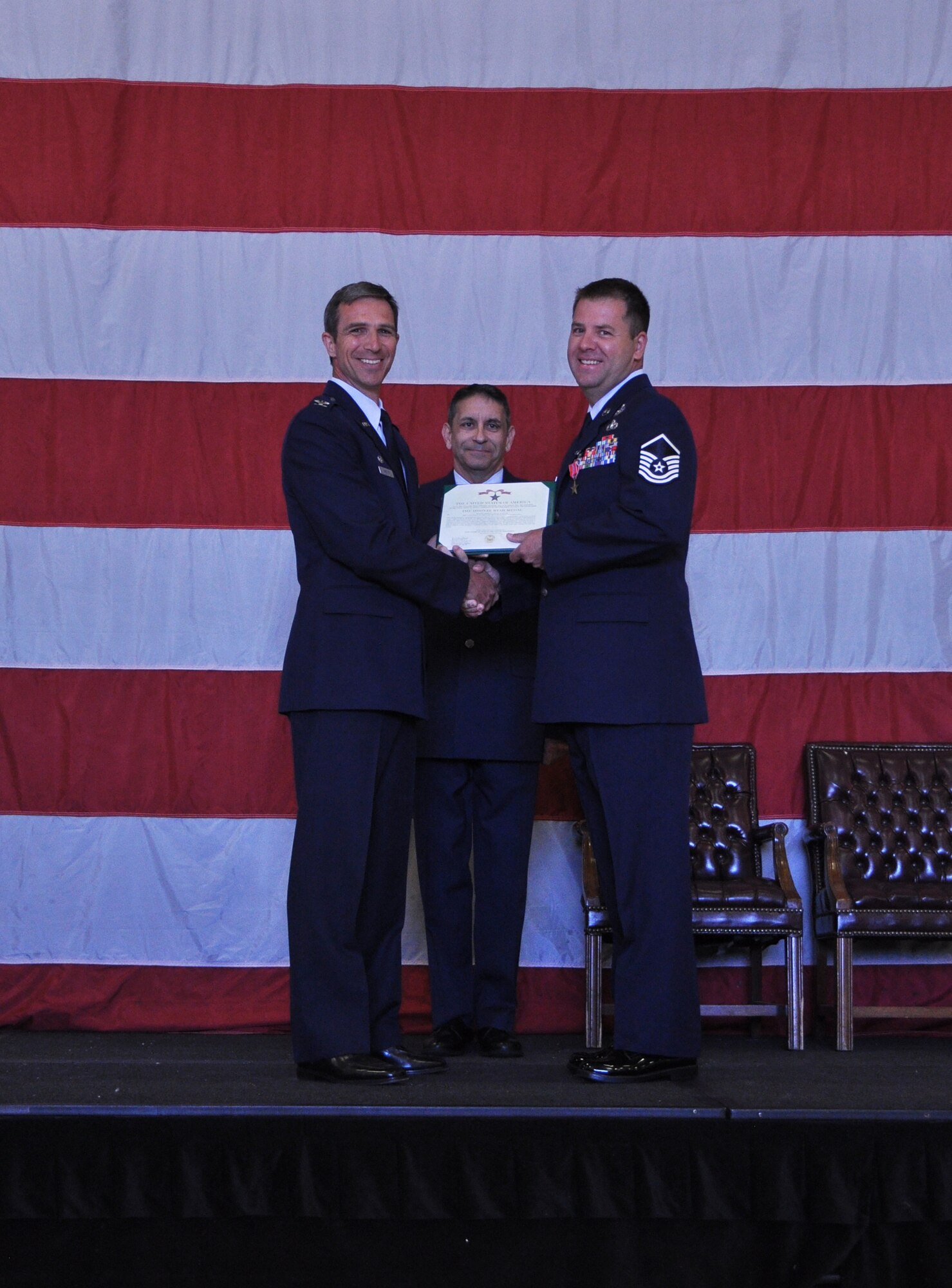 Col. Bryan Radliff (left), 419th Fighter Wing commander, presents a Bronze Star medal to Master Sgt. Stuart Wylie (right), 419th Explosive Ordnance Disposal, during a commander’s call here July 14. 