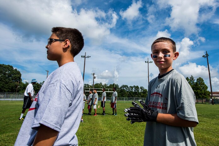 Tyler Deveau, son of Staff Sgt. Jason Deveau, 437th Aircraft Maintenance Squadron jet engine technician, waits in line for training drills during the Andre Roberts Pro Camp, July 15, 2013, at Joint Base Charleston - Weapons Station, S.C. More than 100 base children attended the Andre Roberts Pro Camp on July 15-16. The camp was paid for by Roberts, enabling the children to attend for free. (U.S. Air Force photo/ Senior Airman George Goslin)