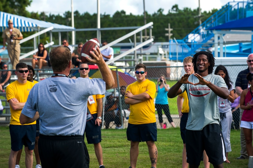 Jim Stoll, Pro Camps organizer, throws a ball to Andre Roberts, Arizona Cardinals wide receiver, to demonstrate proper receiving technique during the Andre Roberts Pro Camp, July 15, 2013, at Joint Base Charleston - Weapons Station, S.C. More than 100 base children attended the Andre Roberts Pro Camp on July 15-16. The camp was paid for by Roberts, enabling the children to attend for free. (U.S. Air Force photo/ Senior Airman George Goslin)
