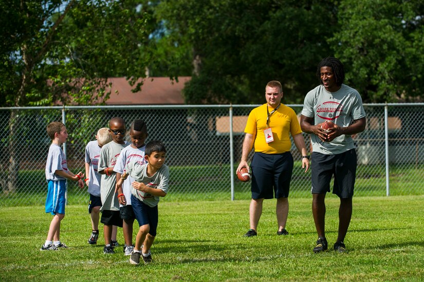 Andre Roberts, Arizona Cardinals wide receiver, prepares to throw a pass to a child during the Andre Roberts Pro Camp, July 15, 2013, at Joint Base Charleston - Weapons Station, S.C. More than 100 base children attended the Andre Roberts Pro Camp on July 15-16. The camp was paid for by Roberts, enabling the children to attend for free. (U.S. Air Force photo/ Senior Airman George Goslin)