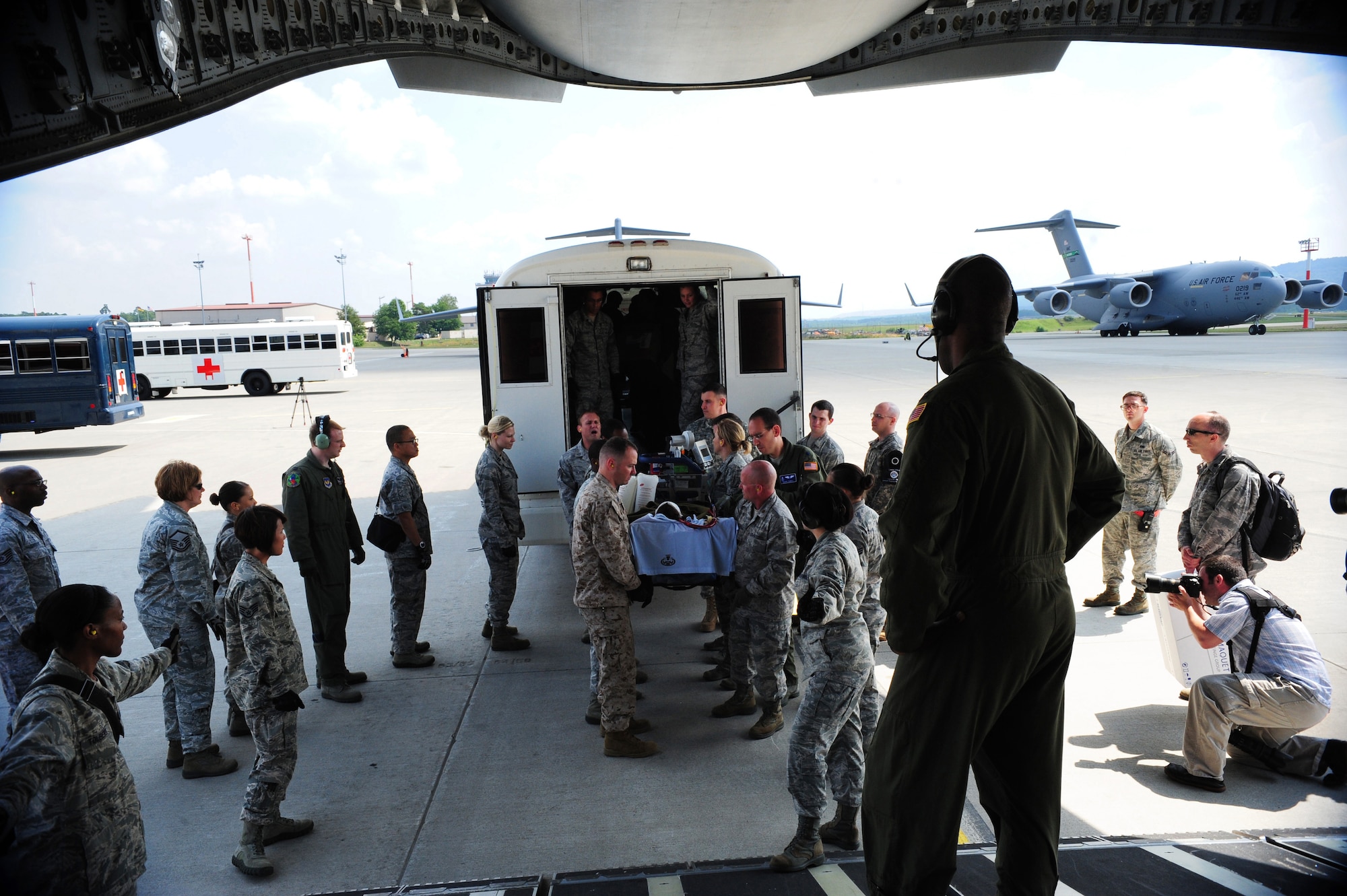 Service members work together to transfer a patient aboard a C-17 Globemaster III July 10, 2013, Ramstein Air Base, Germany. An active-duty Air Force crew made history while flying specialized medical teams and their patient requiring medical equipment never before used on board a transatlantic mission. (U.S. Air Force photo/Senior Airman Hailey Haux)