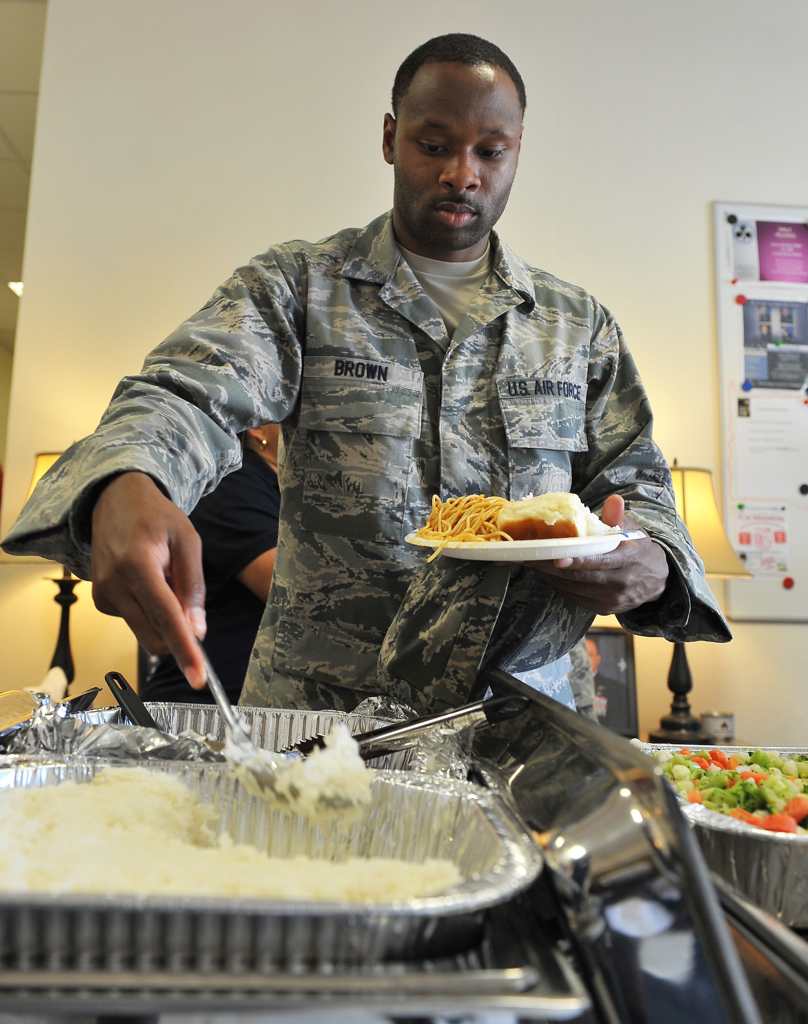 An Airmen grabs a bite to eat at the home-cooked meal event at Club 7, July 11, 2013, Ramstein Air Base, Germany. Club 7 is a place for members of the KMC to hangout, take trips and build camaraderie with other Airmen in a comfortable, alcohol-free environment. (U.S. Air Force photo/Airman Dymekre Allen)