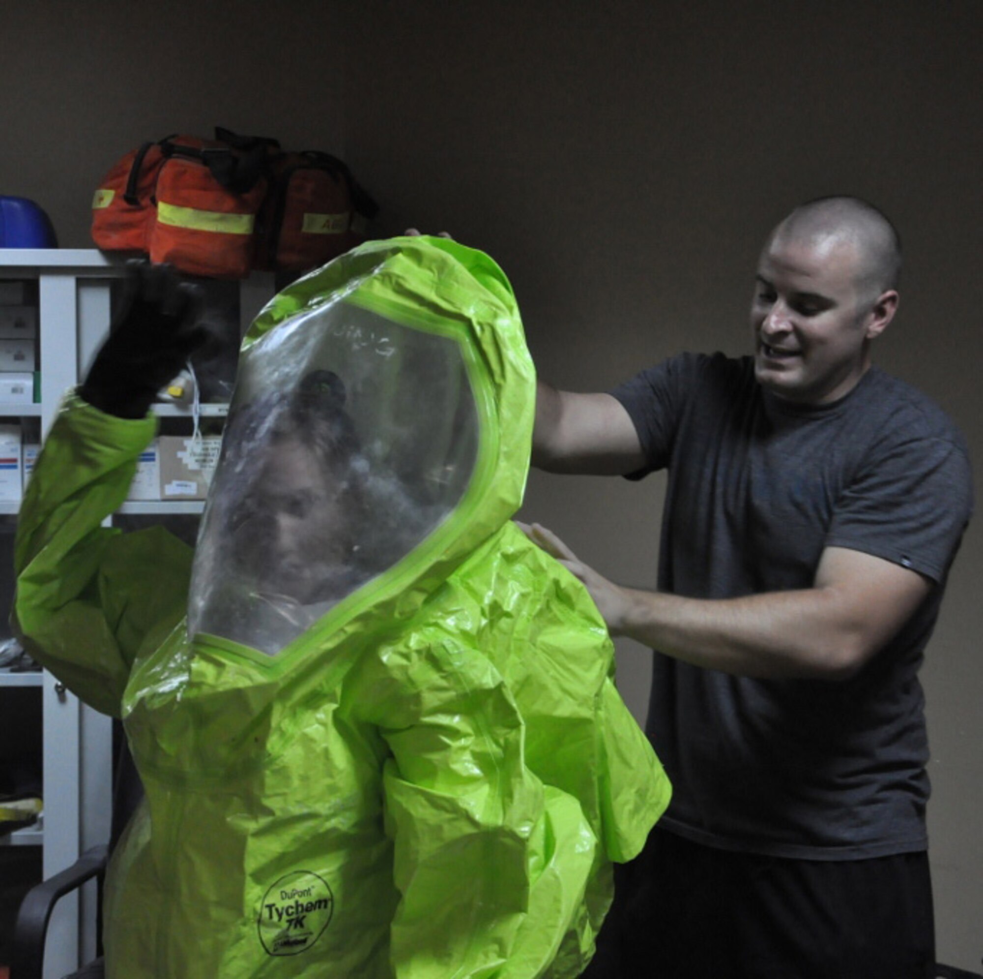 Staff Sgt. Kenneth Mize, 386th Expeditionary Civil Engineer Squadron, assists U.S. Army Spc. Nicole Sullivan, Pennsylvania National Guard, in donning a Level-A protective suit during hazardous material training at an undisclosed location, Southwest Asia, June 4, 2013.  Between May and June 2013, in an effort between the 386th ECES and the Charlie Company, 55th Brigade Special Troops Battalion, more than 60 Soldiers received HAZMAT training, potentially saving the government thousands of dollars.  (U.S. Army photo by Staff Sgt. Shawn Barger)   