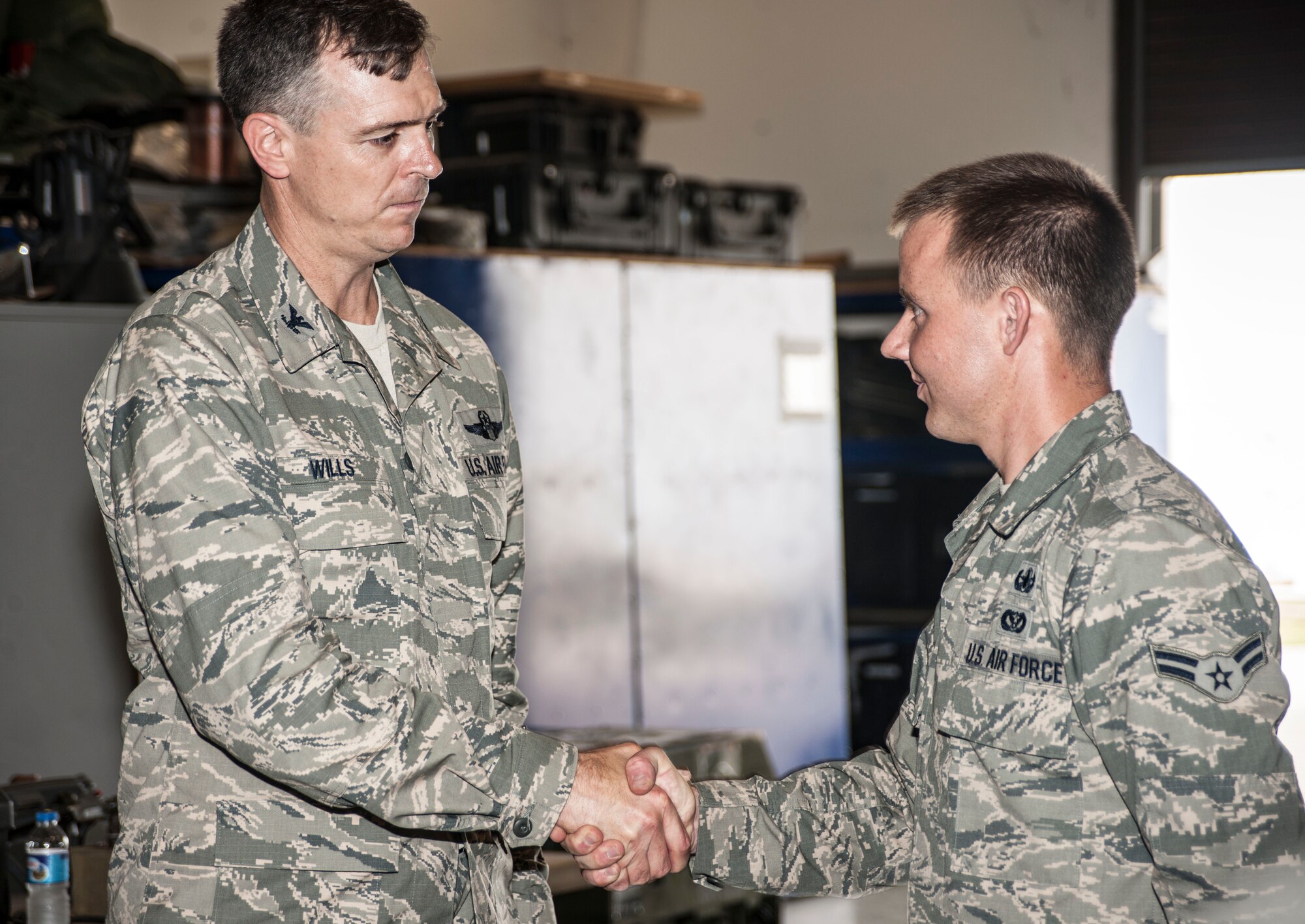 Col. Craig Wills, 39th Air Base Wing commander, coins Airman 1st Class Samuel Bassin, 39th Civil Engineer Squadron explosive ordnance disposal technician, during the commander’s immersion with the EOD flight July 18, 2013, at Incirlik Air Base, Turkey. Bassin received the coin for his exceptional advancement through his career development course. (U.S. Air Force photo by Senior Airman Anthony Sanchelli/Released)
