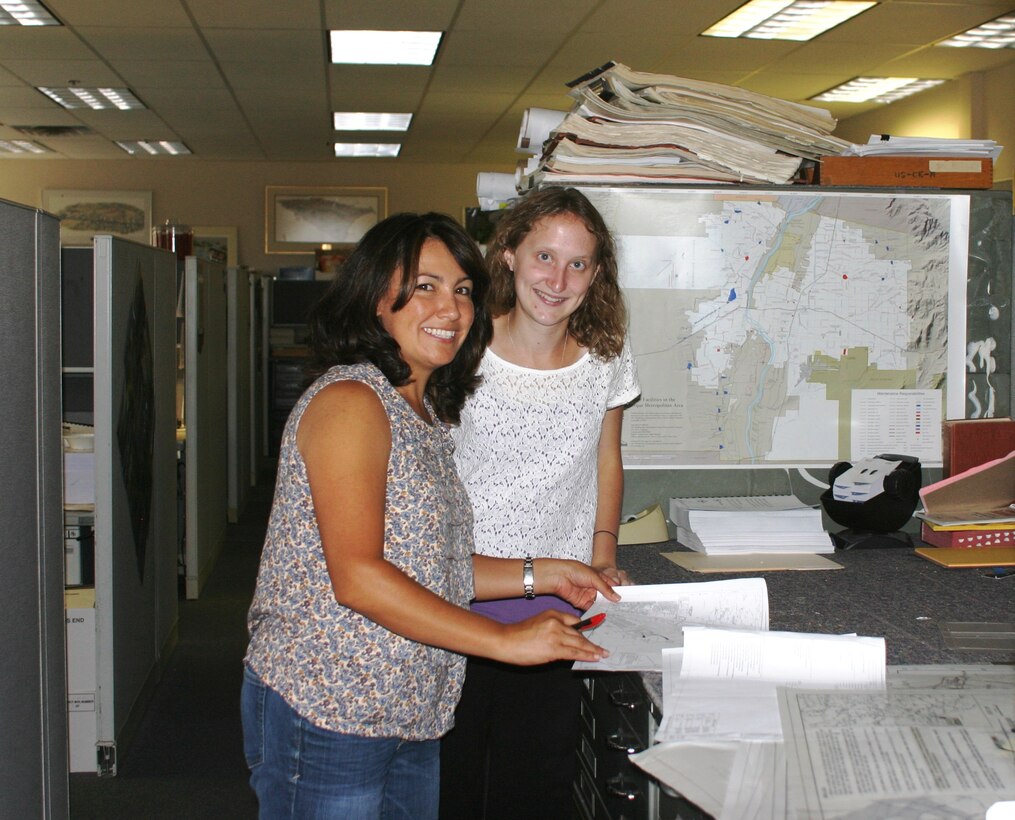 ALBUQUERQUE, N.M., -- University of New Mexico civil engineering student Corey Bowen (right) and Corina Chavez, civil engineer, pause for a moment while discussing a design project, July 8, 2013.  Bowen spent eight weeks this summer as the District’s first STEM intern through a partnership with UNM and assisted with several on-going design projects in the District’s General Engineering Section.