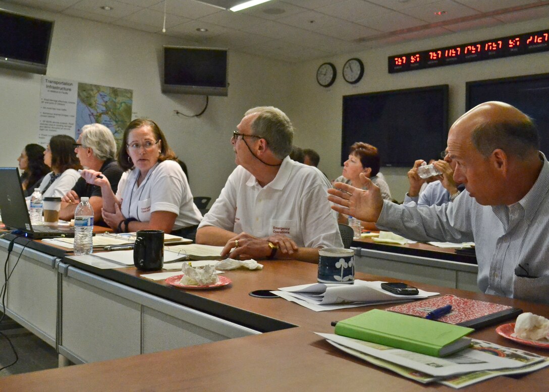 Kelley Aasen (center), USACE South Pacific Division’ s chief of Emergency Management, listens to Clark Frentzen (right), Planning and Policy chief, pose questions about Bay Area evacuation routes during the annual Golden Guardian training held here at SPD Headquarters in San Francisco, Calif., July 17, 2013. The training, designed to provide Corps employees with an overview of response capabilities in the event of a local emergency or natural disaster, emphasized the coordination between the Corps of Engineers and the Federal Emergency Management Agency. (U.S. Army photo by Randy Gon/Released)