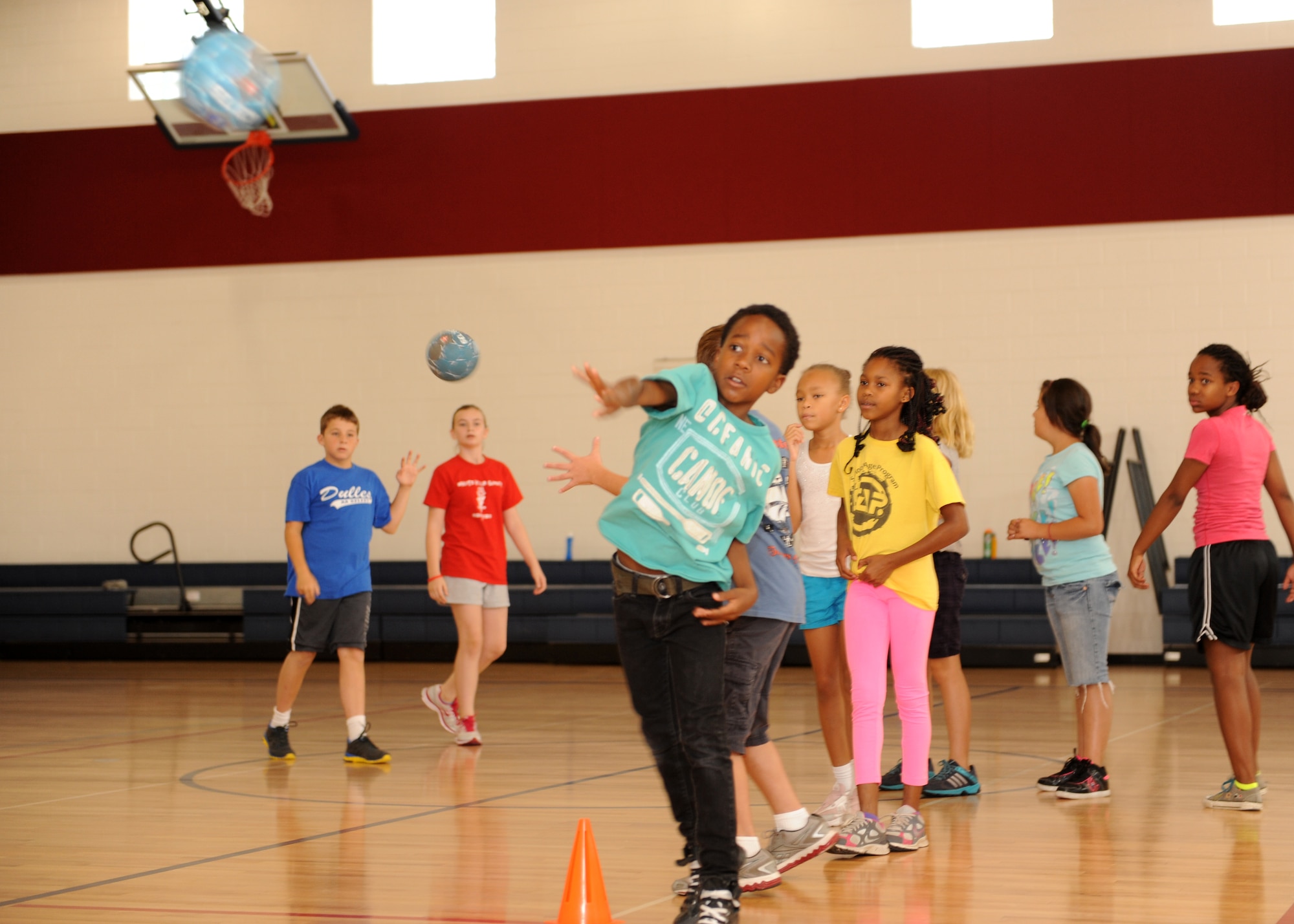 Sean Brown, son of Master Sgt. Michael Brown, 460th Space Wing Equal Opportunity Office, lofts a ball July 16, 2013, at the youth center on Buckley Air Force Base, Colo. The Sidelines Sports Camp taught unique sports like handball and fencing. (U.S. Air Force photo by Senior Airman Marcy Glass/Released)