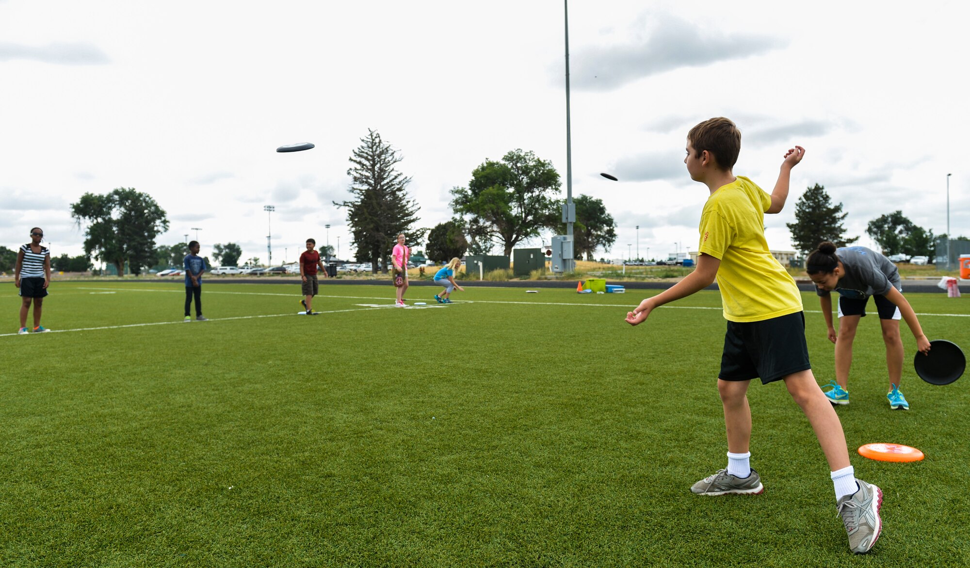 Ryan Yates, son of Lt. Col. Nathan Yates, 8th Space Warning Squadron, tosses a Frisbee during the Sidelines Sports Camp July 15, 2013, on Buckley Air Force Base, Colo.  Youths ages 9 and older participated in a weeklong camp that presented them the opportunity to participate in nontraditional sports such as ultimate Frisbee and lacrosse. (U.S. Air Force photo by Staff Sgt. Paul Labbe/Released)