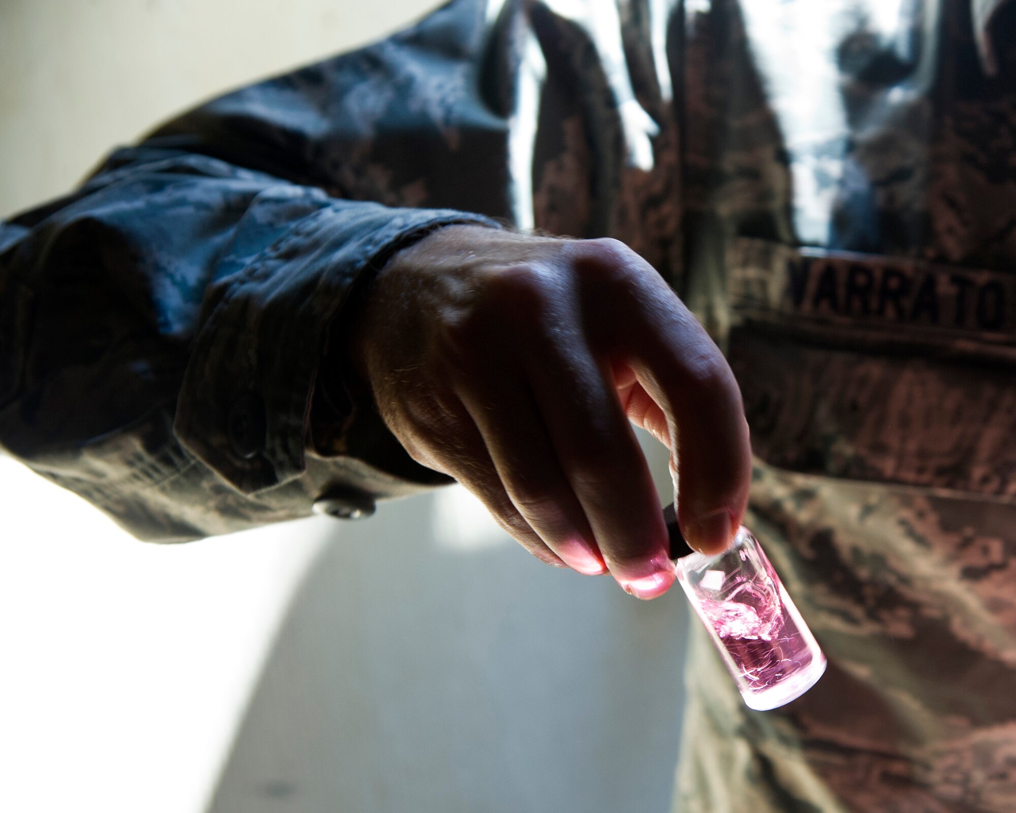 ALTUS AIR FORCE BASE, Okla. -- Staff Sgt. Marshall Varrato, 97th Medical Operations Squadron bioenvironmental engineering NCO in charge of readiness and training, swirls a water sample during a routine water sampling at the main water line on base. Members of the 97th MDOS bioenvironmental engineering flight conduct water samplings twice a month. The samples are collected and then delivered to a lab in Elk City, Okla. where they are tested for contaminants. (U.S. Air Force photo by Senior Airman Kenneth W. Norman / Released)